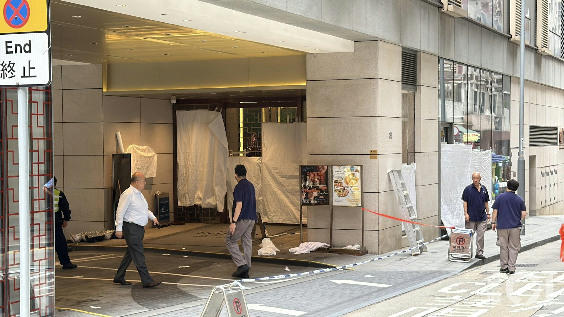另有4人懷疑被玻璃碎片濺中受傷,酒店職員用白布圍著地下玻璃門。 (馬耀文攝)