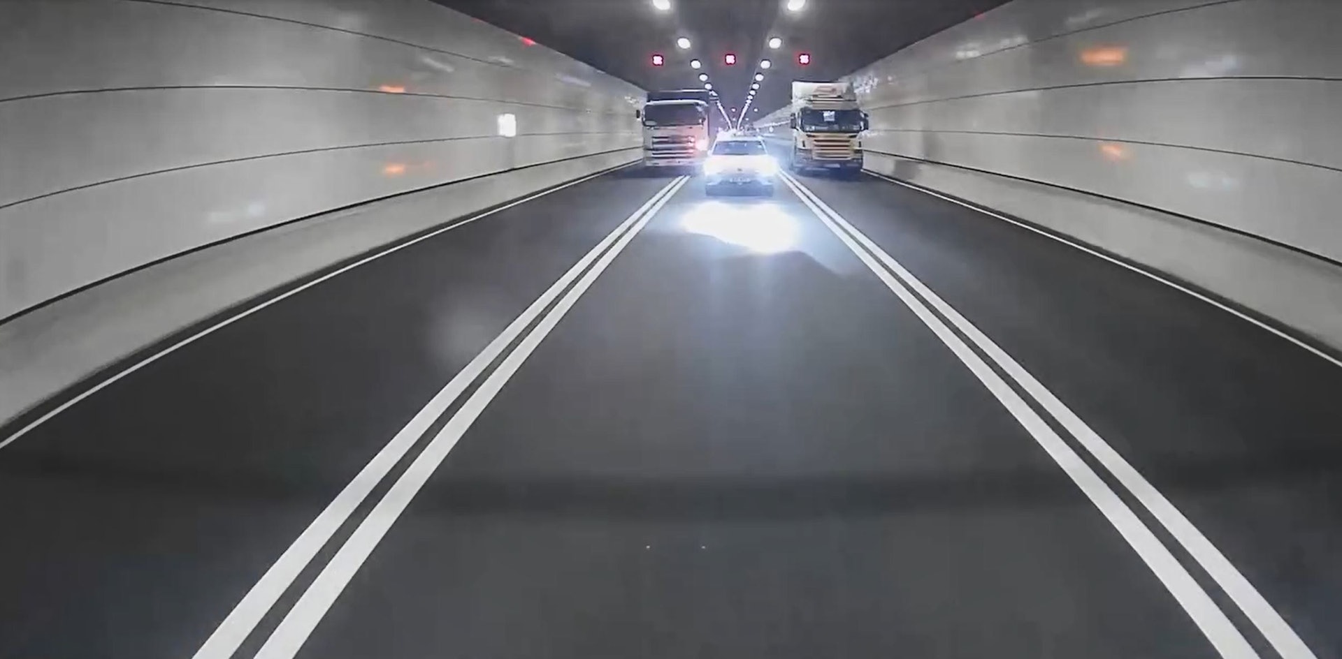 拖頭和密斗貨車分別在左線和中線並排行駛,適逢中線有一輛私家車,拖頭繼續沿左線行駛,密斗貨車切往右線避車。(Facebook群組「車cam L(香港群組)」/Wan Cho影片截圖)