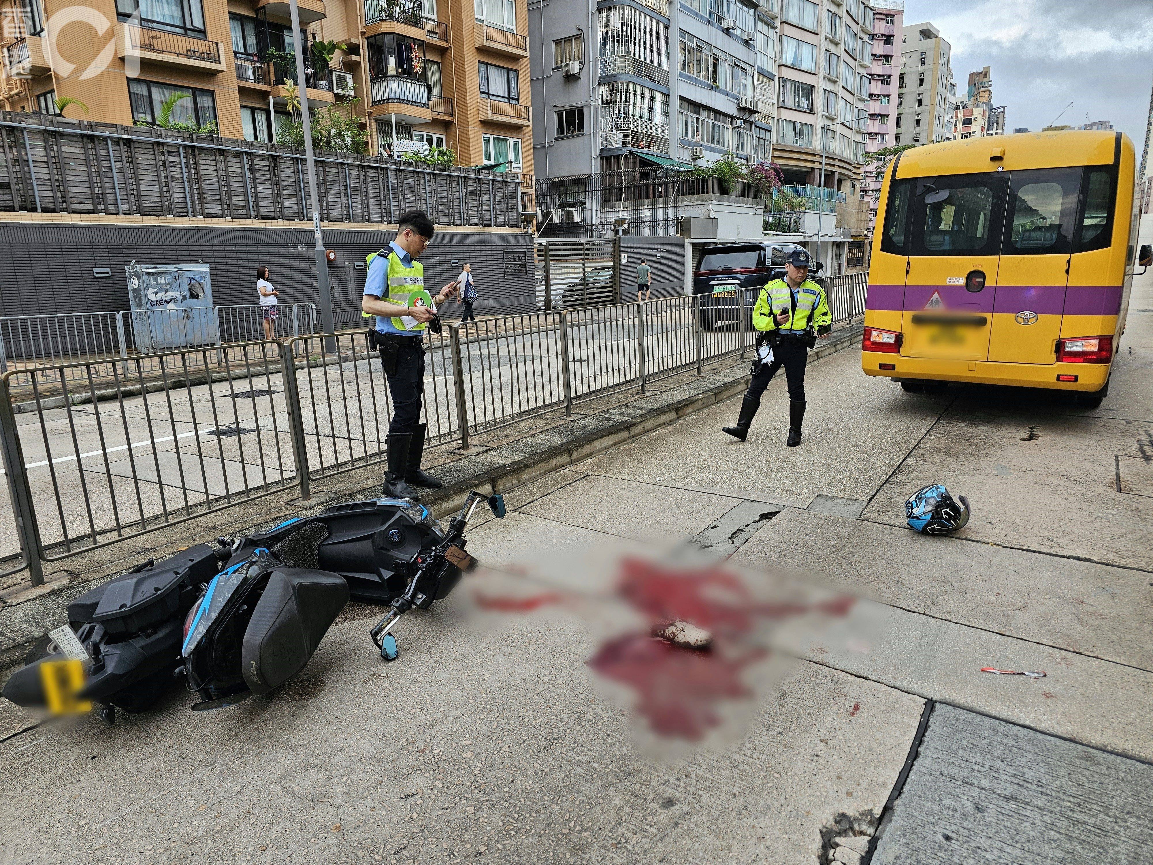 現場可見，電單車翻側於圍欄邊；路面遺落頭盔、一隻鞋及大灘血漬。（梁偉權攝）