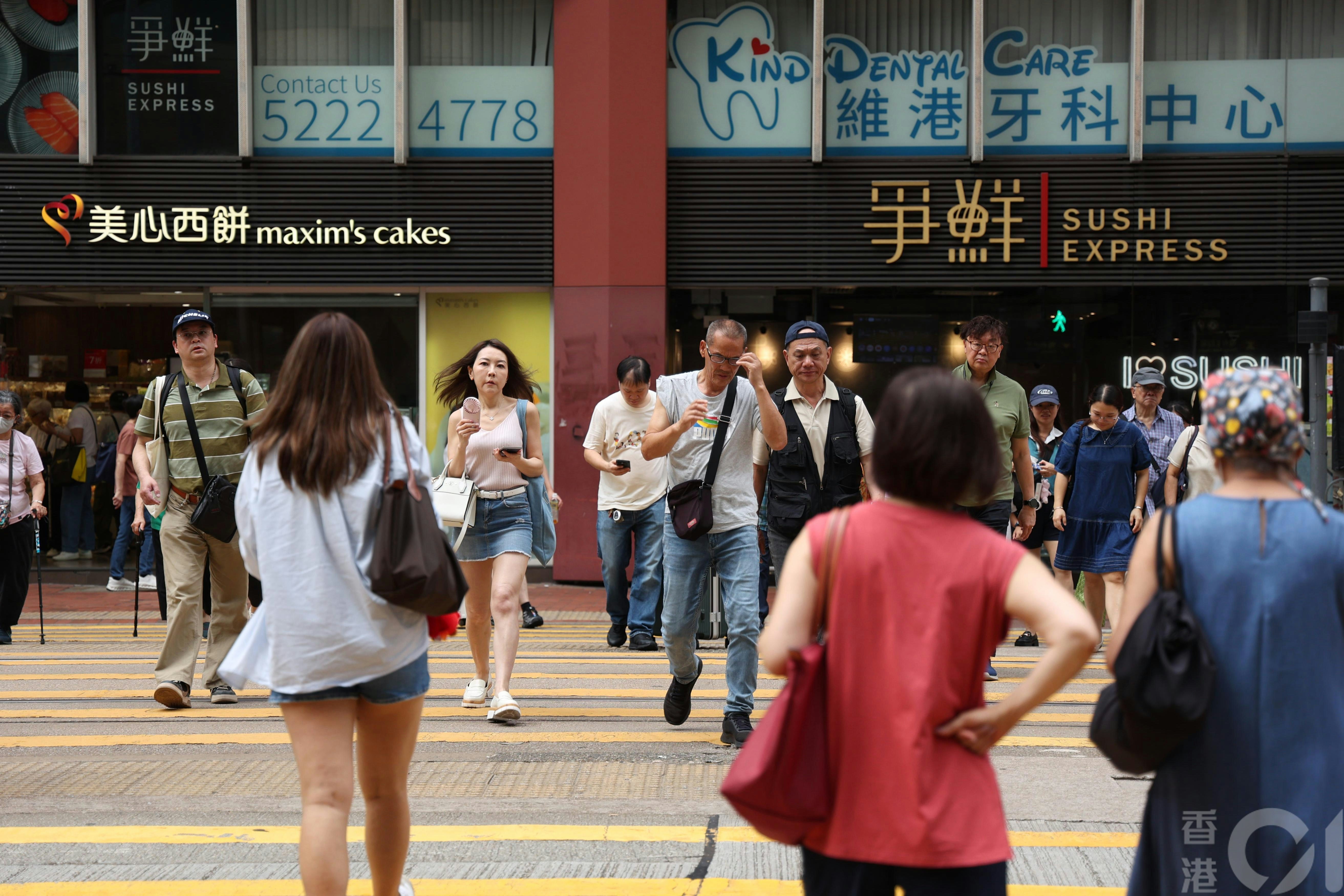 天文台5月25日下午錄得市區32度。在炮台山街頭，有過馬路行人用手提風扇仔降溫。（資料圖片／鄧倩螢攝）
