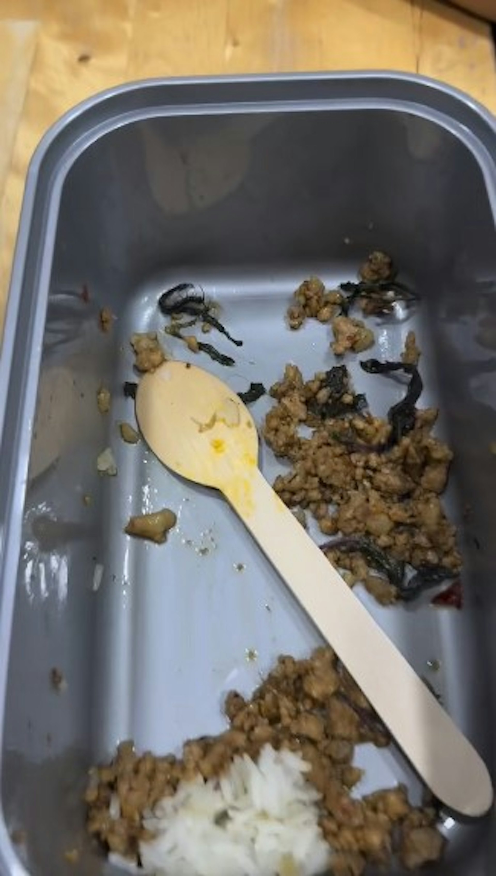 飯盒藏有1條黑色、身型細長、明顯看見多隻腳,疑為蜈蚣的昆蟲。(「threads@_chris_leee」影片截圖) 飯盒藏有1條黑色、身型細長、明顯看見多隻腳,疑為蜈蚣的昆蟲。(「threads@_chris_leee」影片截圖)