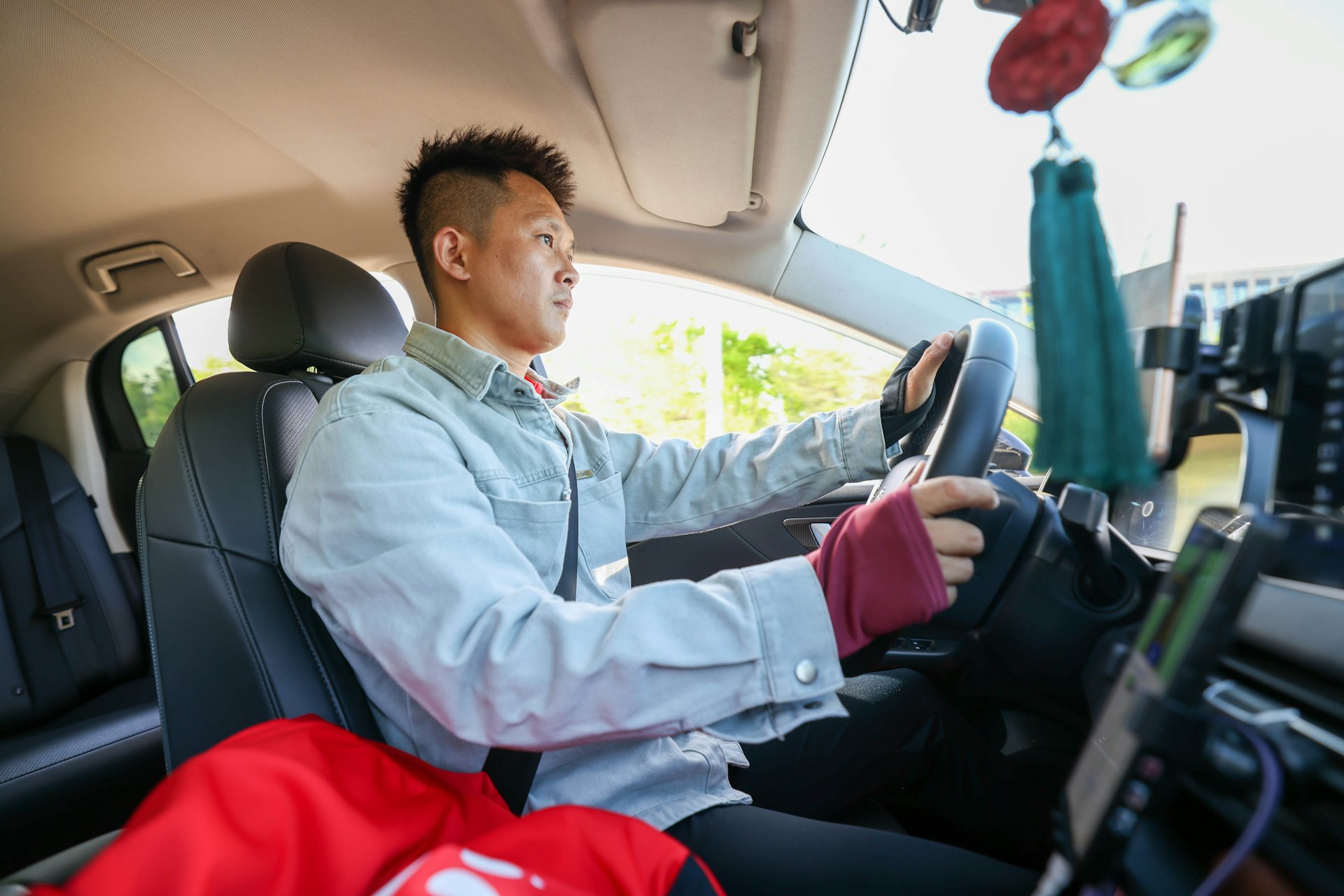 5月19日,東北超長春隊球員張亮亮駕駛網約車行駛在路上。(新華社) 5月19日,東北超長春隊球員張亮亮駕駛網約車行駛在路上。(新華社)