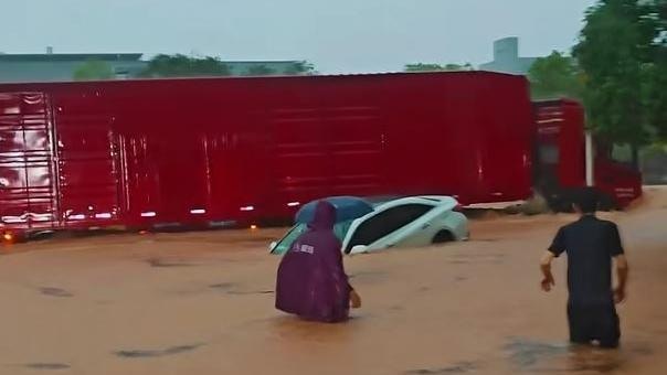 5月29日河源市龍川縣因暴雨積水嚴重，一名女司機因積水漫過車頂受困車內。（截取自微信視頻號@羊城晚報）