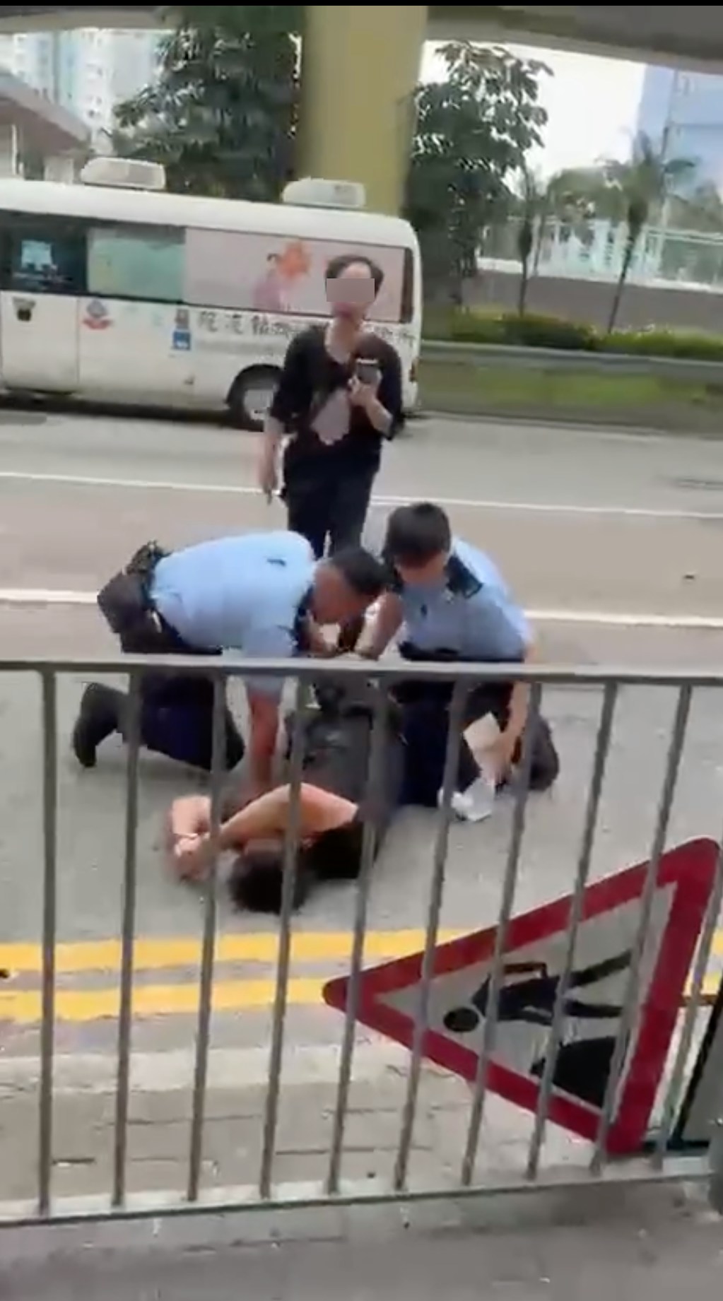 起初一男被制服地上，同行者邊罵警員、邊以手機拍攝。（網上影片截圖）