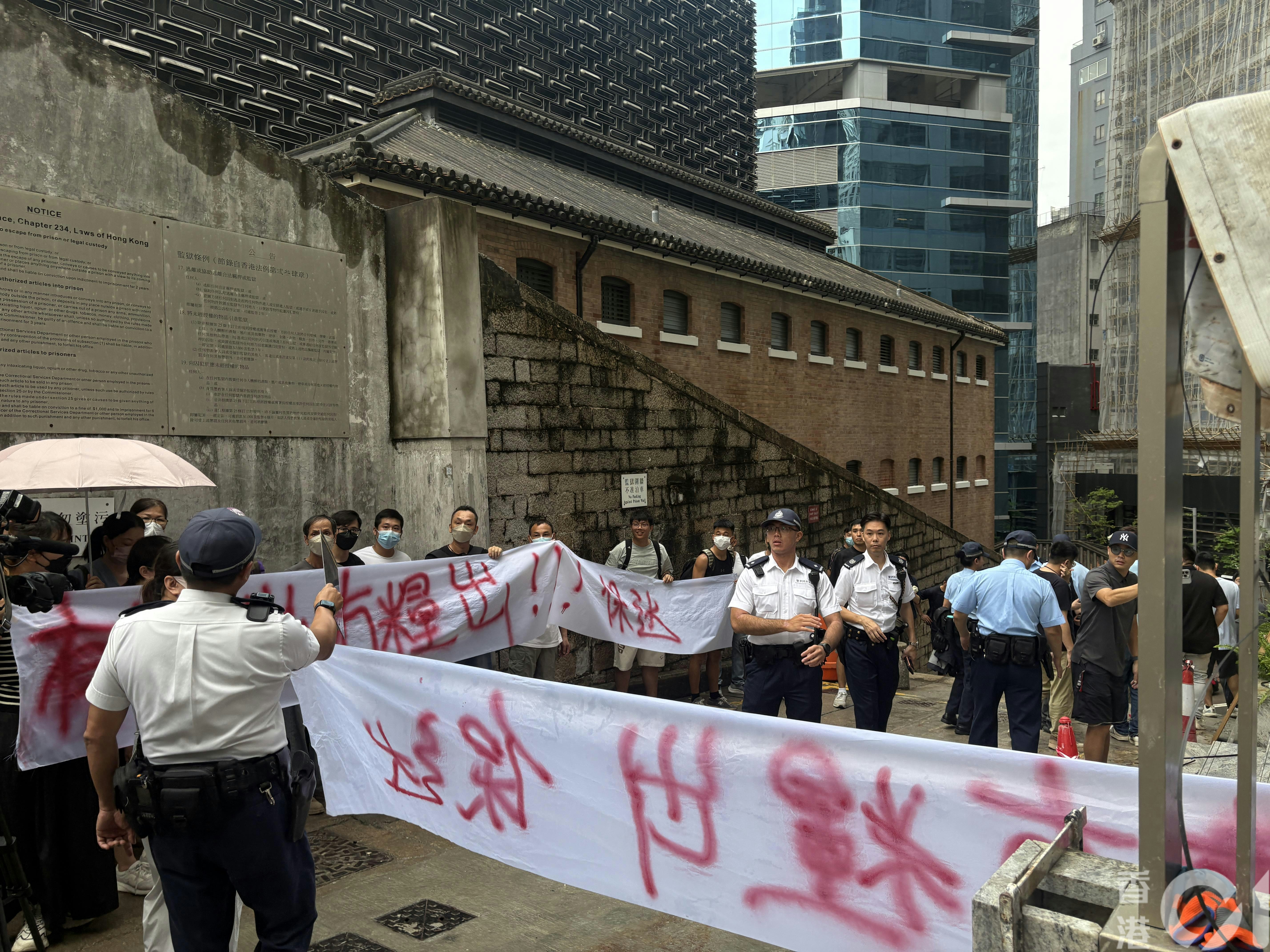 中環贊善裡一個地盤今（8日）早9時許有13男10女到場拉橫額申訴，包括地盤工人及清潔工。（陳佩瑩攝）