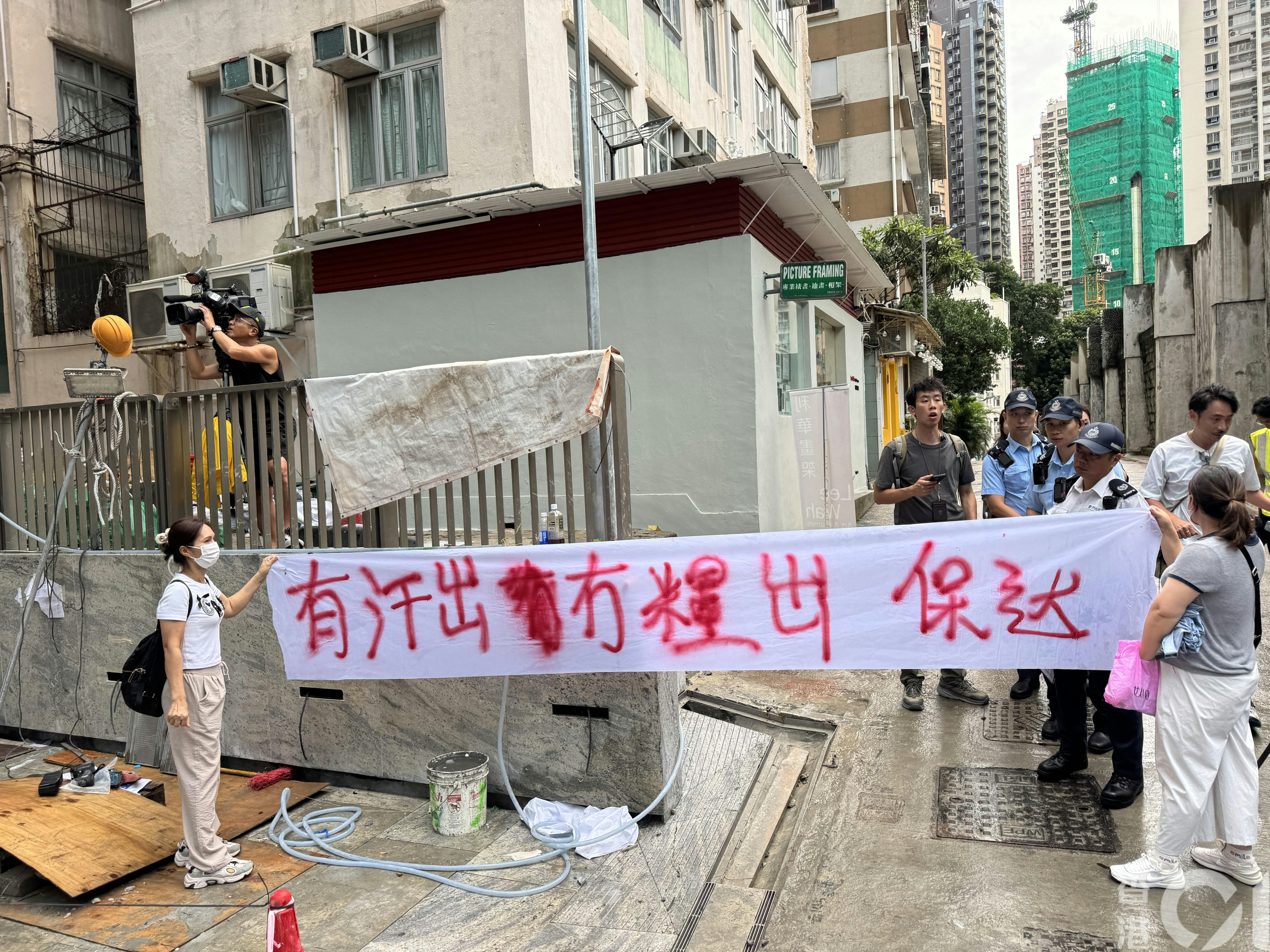 中環贊善裡一個地盤今（8日）早9時許有13男10女到場拉橫額申訴，包括地盤工人及清潔工。（陳佩瑩攝）