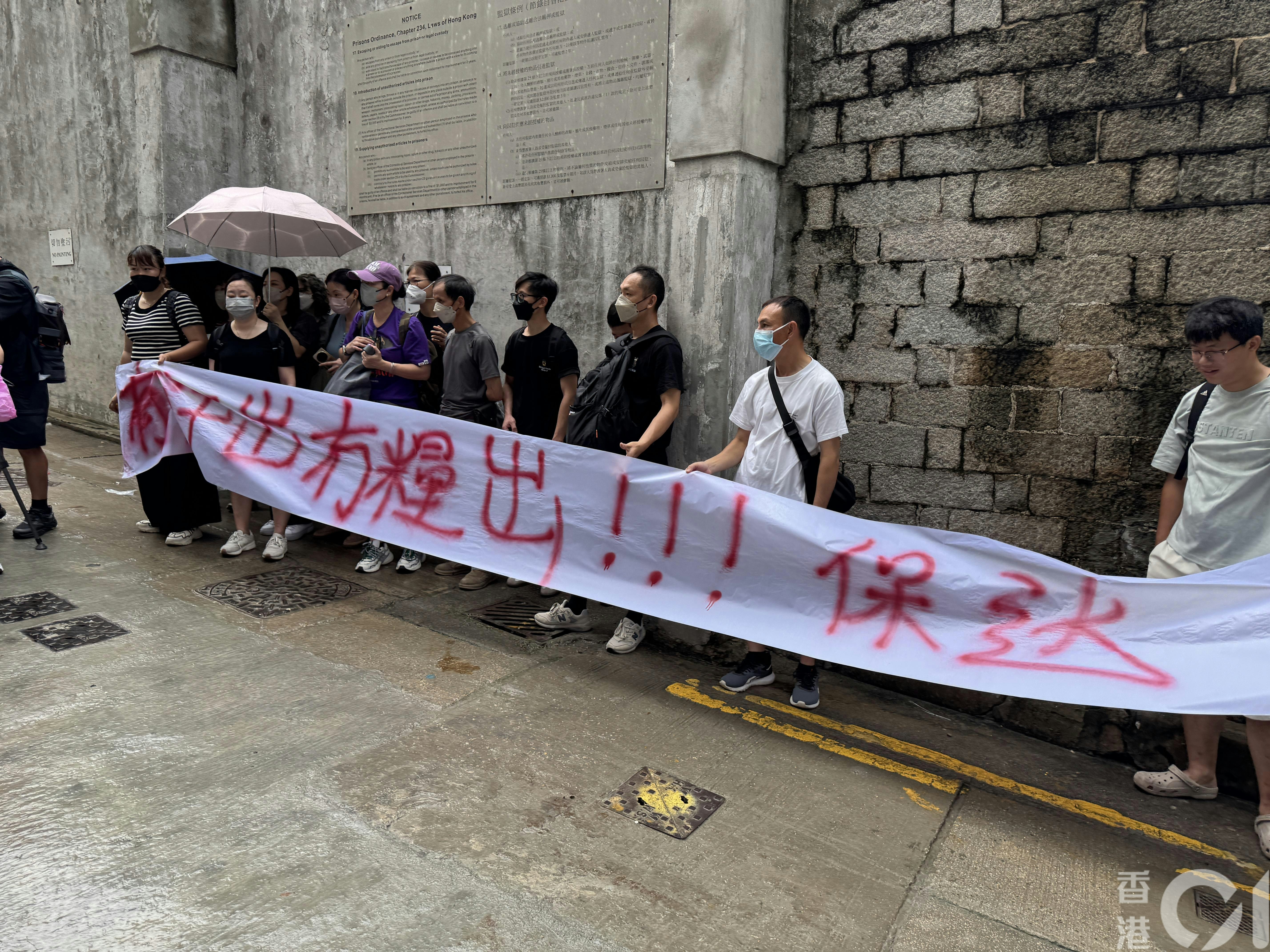 中環贊善裡一個地盤今早（8日）9時許有13男10女工人到場拉橫額申訴，包括地盤工人及清潔工。（陳佩瑩攝）