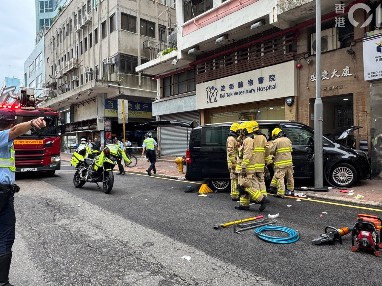 一輛客貨車在土瓜灣貴州街剷上行人路，撞向安慶大廈門口外牆，傷及途人；大批消防員到場救援。（鄭嘉惠攝）