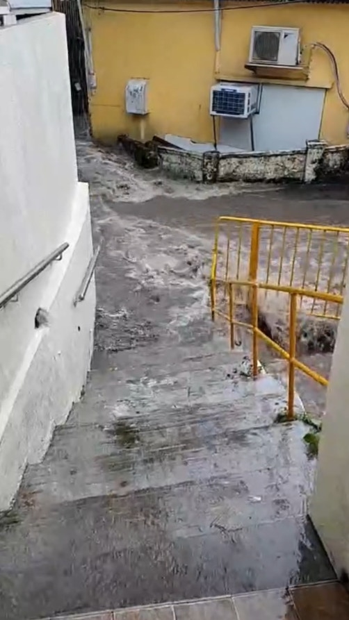 從片段中可見，大量雨水流經井頭村內的窄巷，瞬間變成湍急的河流，大量黃泥水不斷湧下，居民出入嚴重受阻，場面駭人。（屯門友片段截圖）