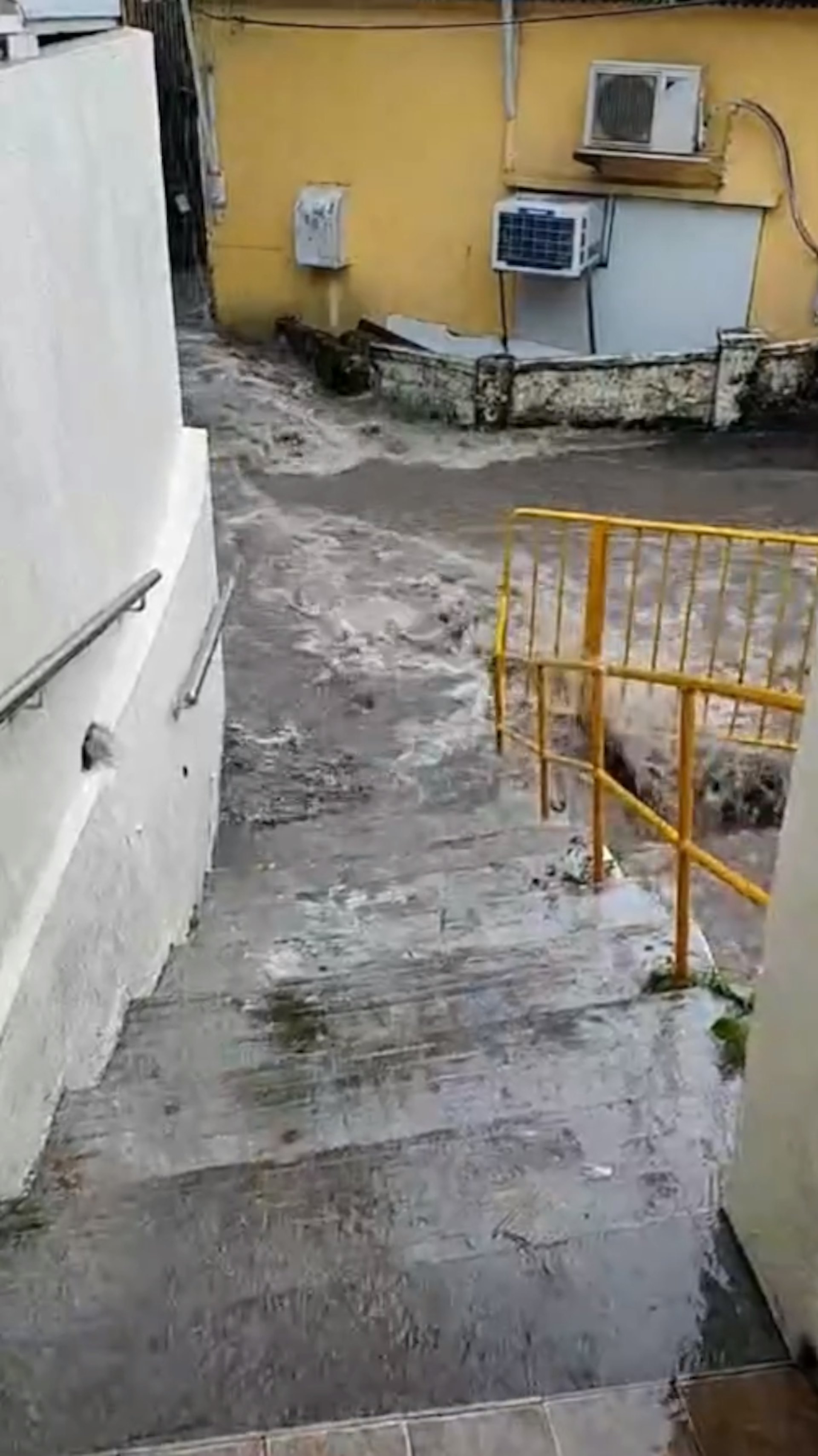 從片段中可見,大量雨水流經井頭村內的窄巷,瞬間變成湍急的河流,大量黃泥水不斷湧下,居民出入嚴重受阻,場面駭人。(屯門友片段截圖) 從片段中可見,大量雨水流經井頭村內的窄巷,瞬間變成湍急的河流,大量黃泥水不斷湧下,居民出入嚴重受阻,場面駭人。(屯門友片段截圖)