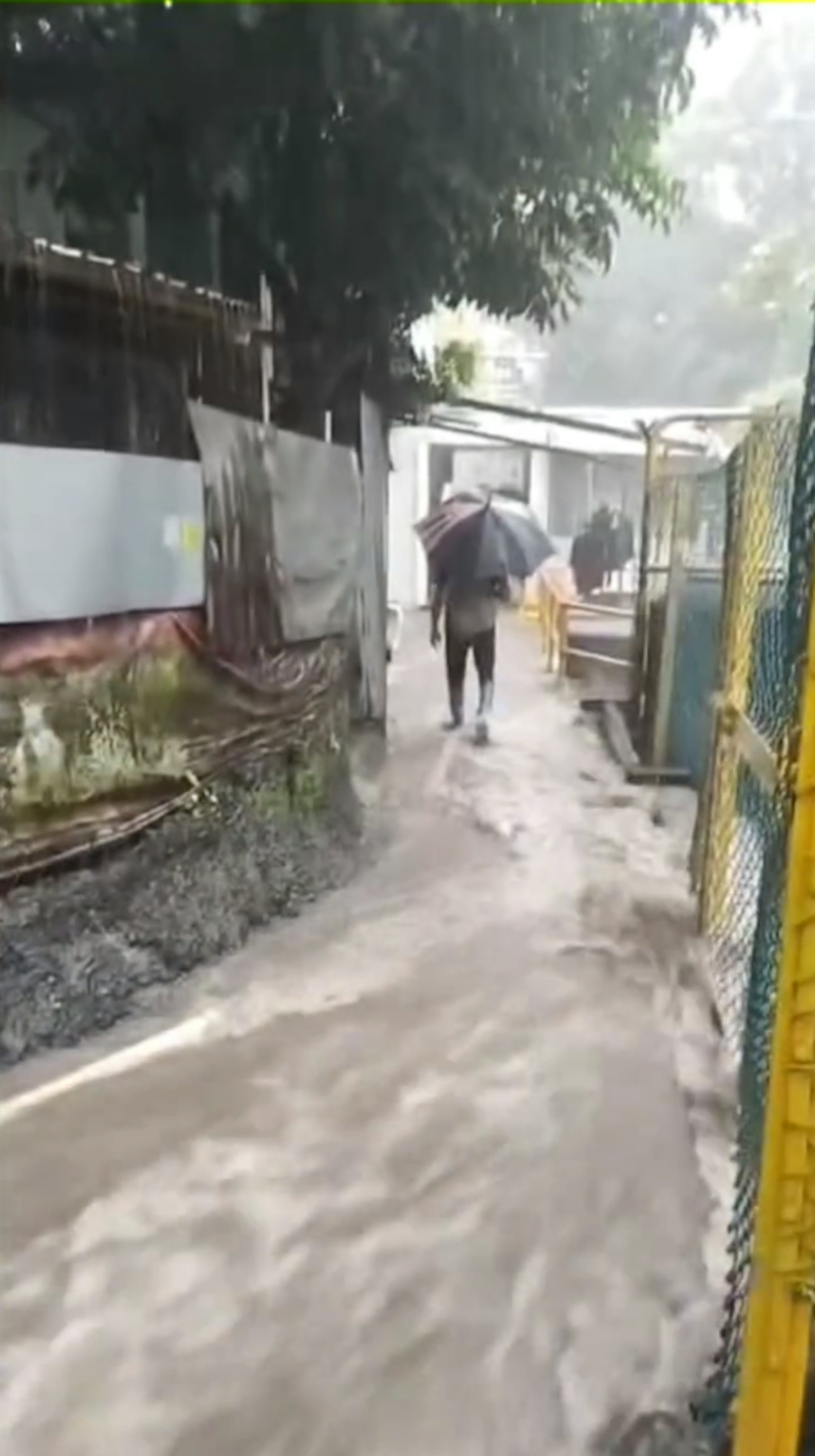 大量雨水流經井頭村內的窄巷,瞬間變成湍急的河流,大量黃泥水不斷湧下,居民出入嚴重受阻,場面駭人。(屯門友片段截圖) 大量雨水流經井頭村內的窄巷,瞬間變成湍急的河流,大量黃泥水不斷湧下,居民出入嚴重受阻,場面駭人。(屯門友片段截圖)