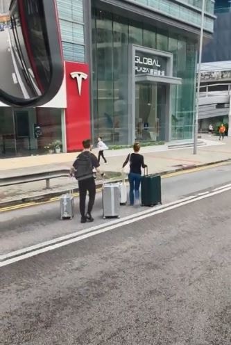 該對男女隨後拖行行李箱，急步橫跨2條行車線（車cam L（香港群組）/文迪影片截圖）