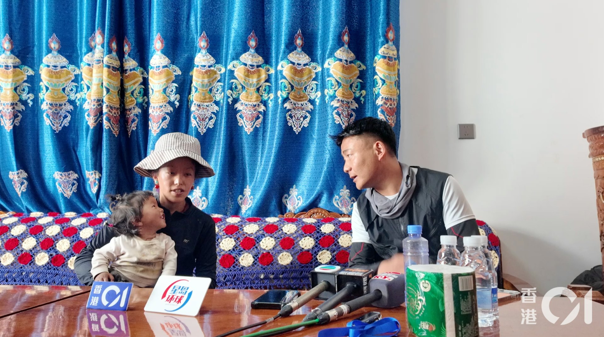 桑傑(左)今年24歲,目前在當地小學擔任廚師,受訪時她懷裡抱著1歲半的孩子。由於桑傑不諳普通話,採訪由長所鄉農業專業技術人員次仁元旦(右)協助翻譯。(香港01 鄭寧) 桑傑(左)今年24歲,目前在當地小學擔任廚師,受訪時她懷裡抱著1歲半的孩子。由於桑傑不諳普通話,採訪由長所鄉農業專業技術人員次仁元旦(右)協助翻譯。(香港01 鄭寧)