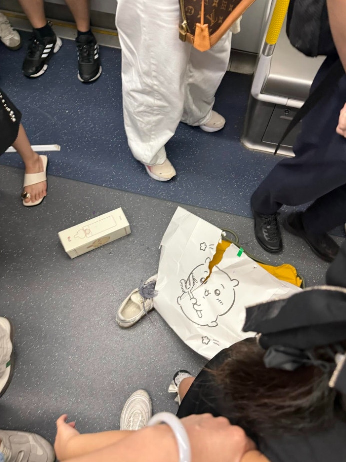 車廂地上散落雜物，包括1個破裂的紙袋、1隻甩脫的鞋等，乘客圍在旁邊。（Threads@qqbaby_____shop）
