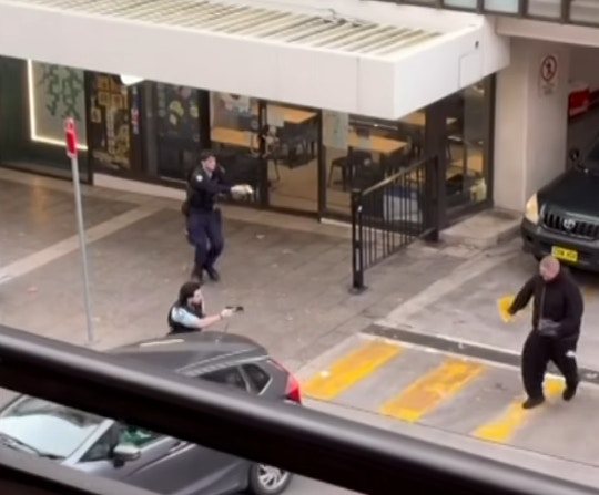 2名男子遇警截查即转身逃跑，警员迅速从后追截，双方随后在街头爆发对峙。（网上影片截图）