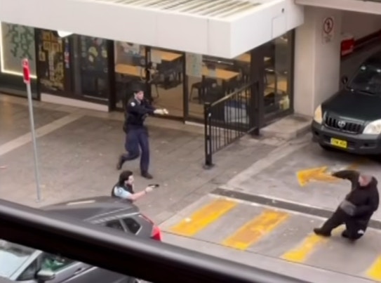 为控制场面及保障途人安全，警员拔出电击枪射击，该男子被击中倒地后情绪依然失控，在地上不断挥舞利刀。（网上影片截图）