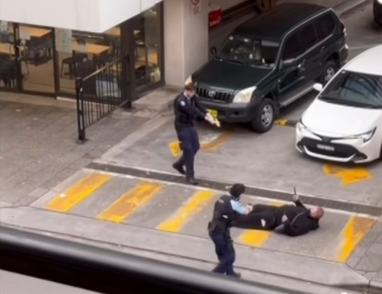 为控制场面及保障途人安全，警员拔出电击枪射击，该男子被击中倒地后情绪依然失控，在地上不断挥舞利刀。（网上影片截图）