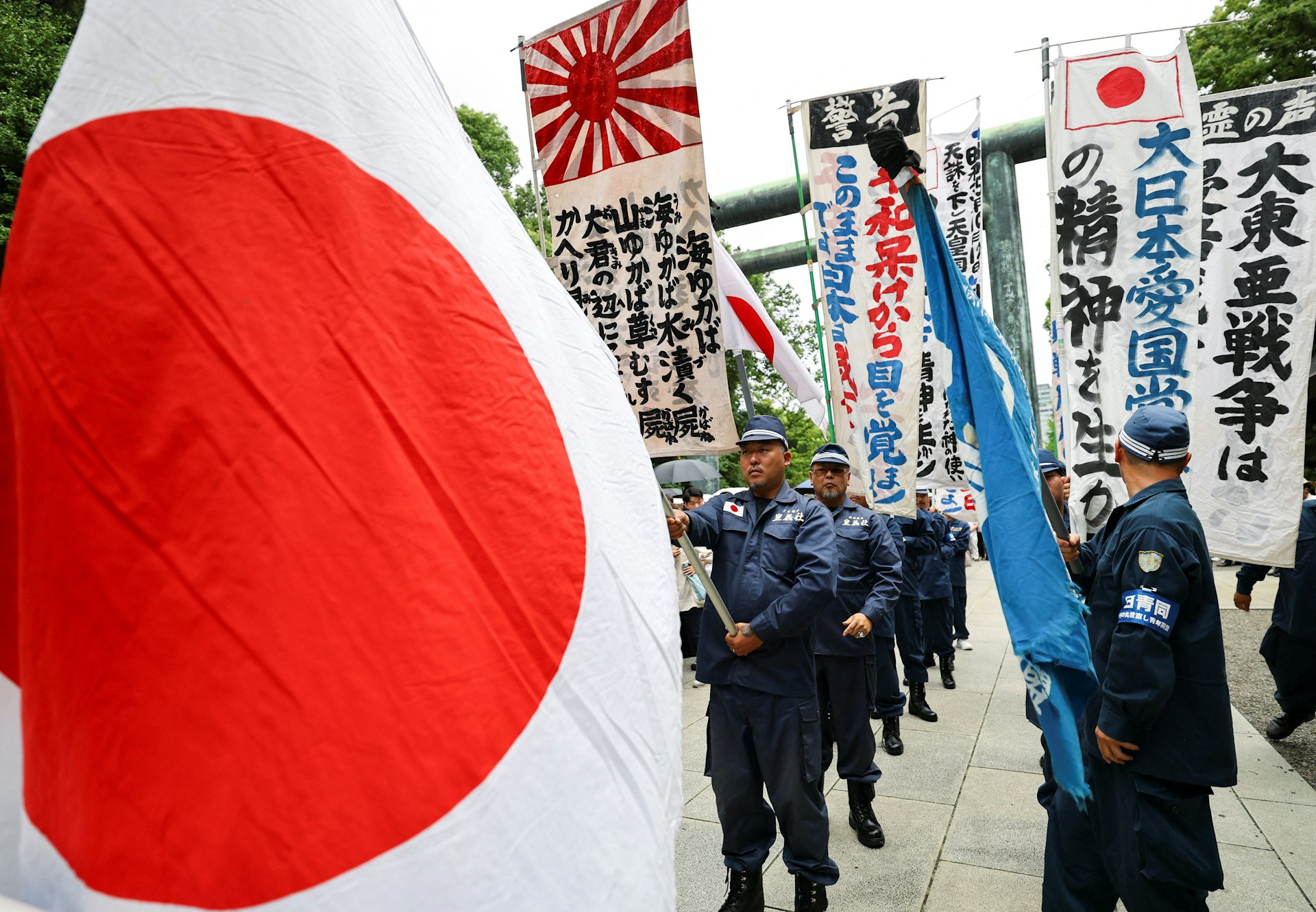 2026年8月15日,日本东京,右翼团体成员在靖国神社手持日本国旗和标语,悼念二战死难者,当日是日本二战投降81周年纪念日。