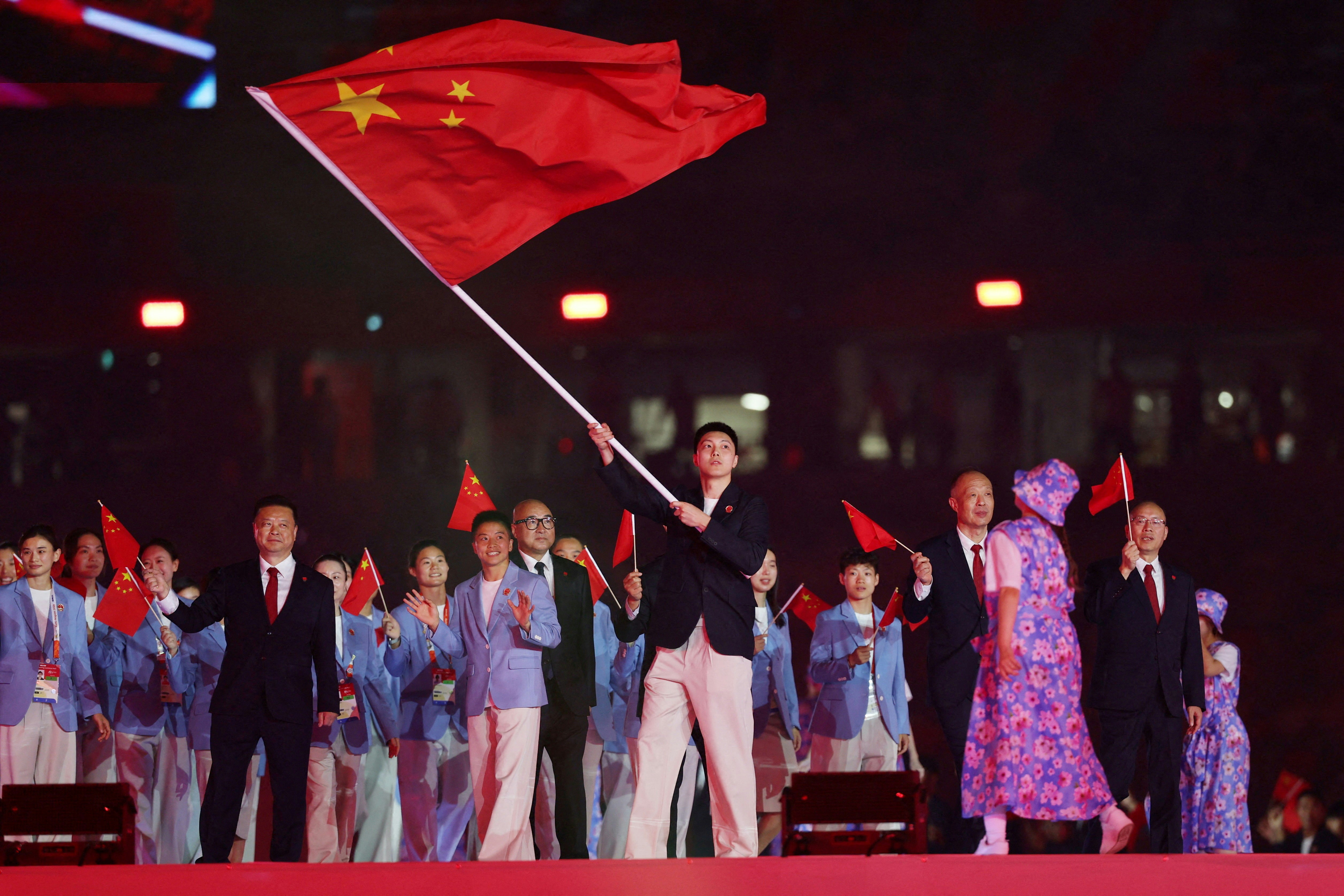 2026年9月19日，名古屋亚运开幕礼，中国男子篮球运动员胡明轩和女子拳击运动员吴愉担任旗手带领代表团入场。（Reuters）