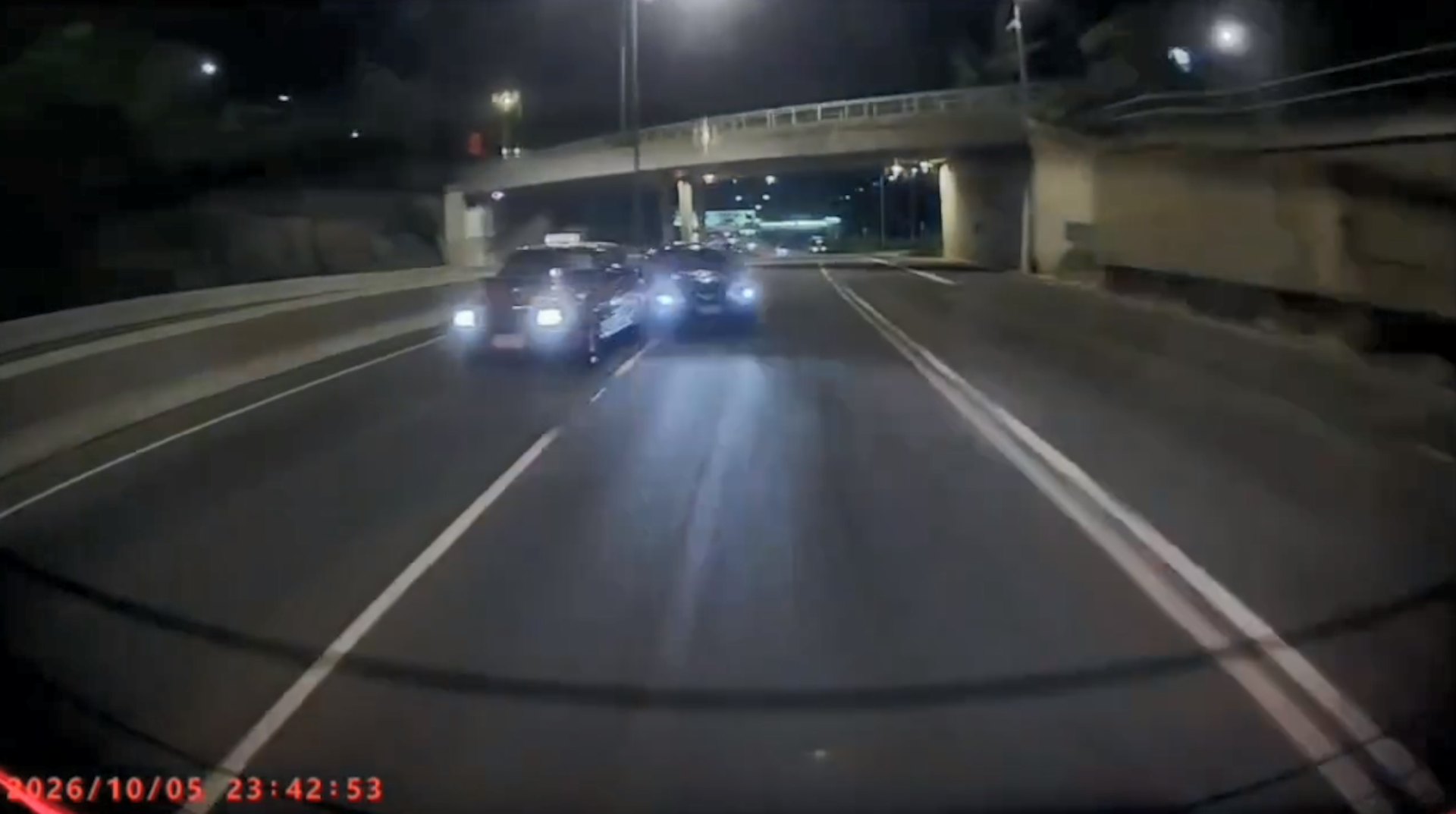 黑色私家車高速橫越兩線時,車身擦撞的士。