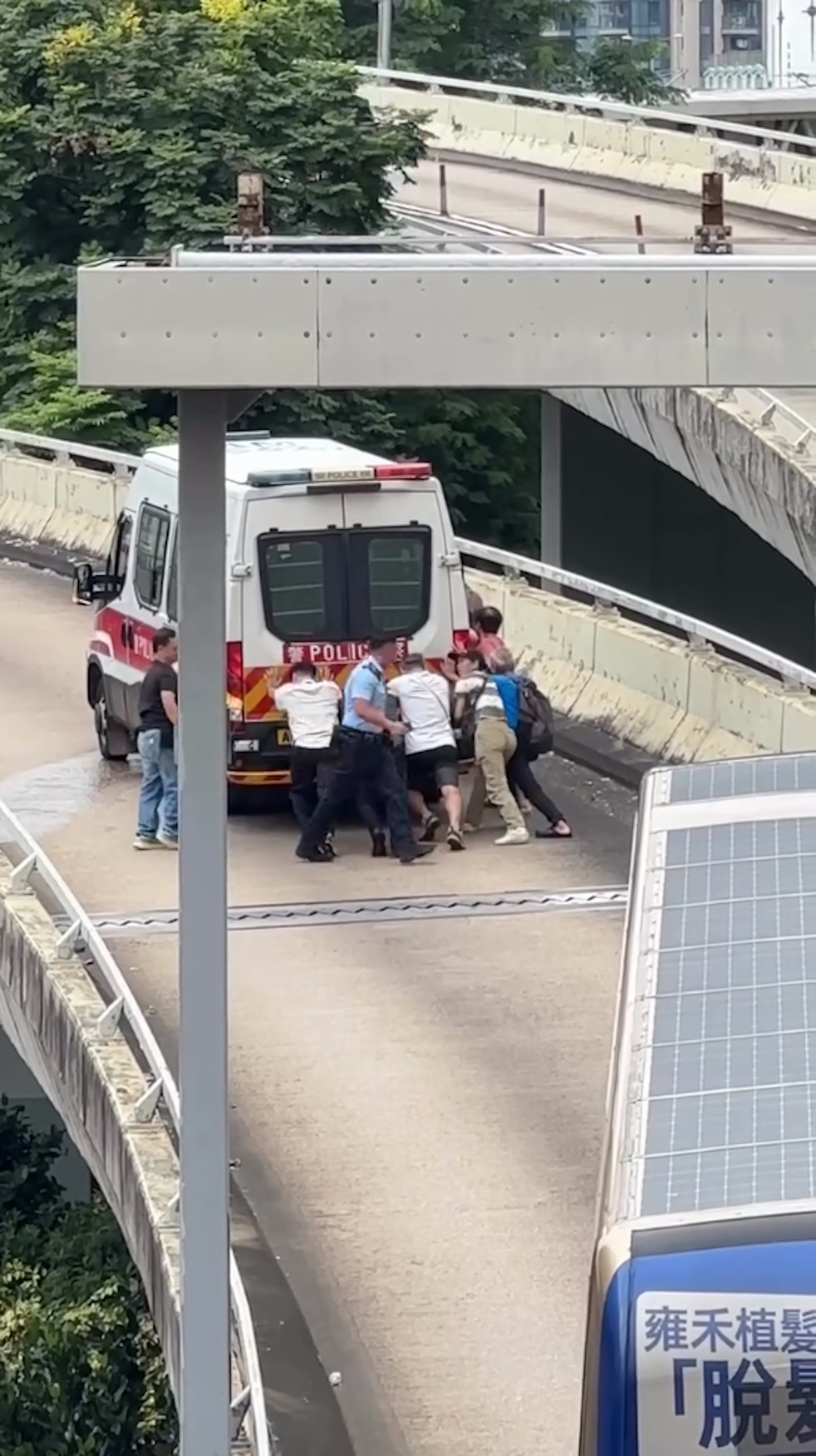 一輛警車於一條行車天橋「死火」,9人合力推車。(Facebook車cam L(香港群組)影片截圖)