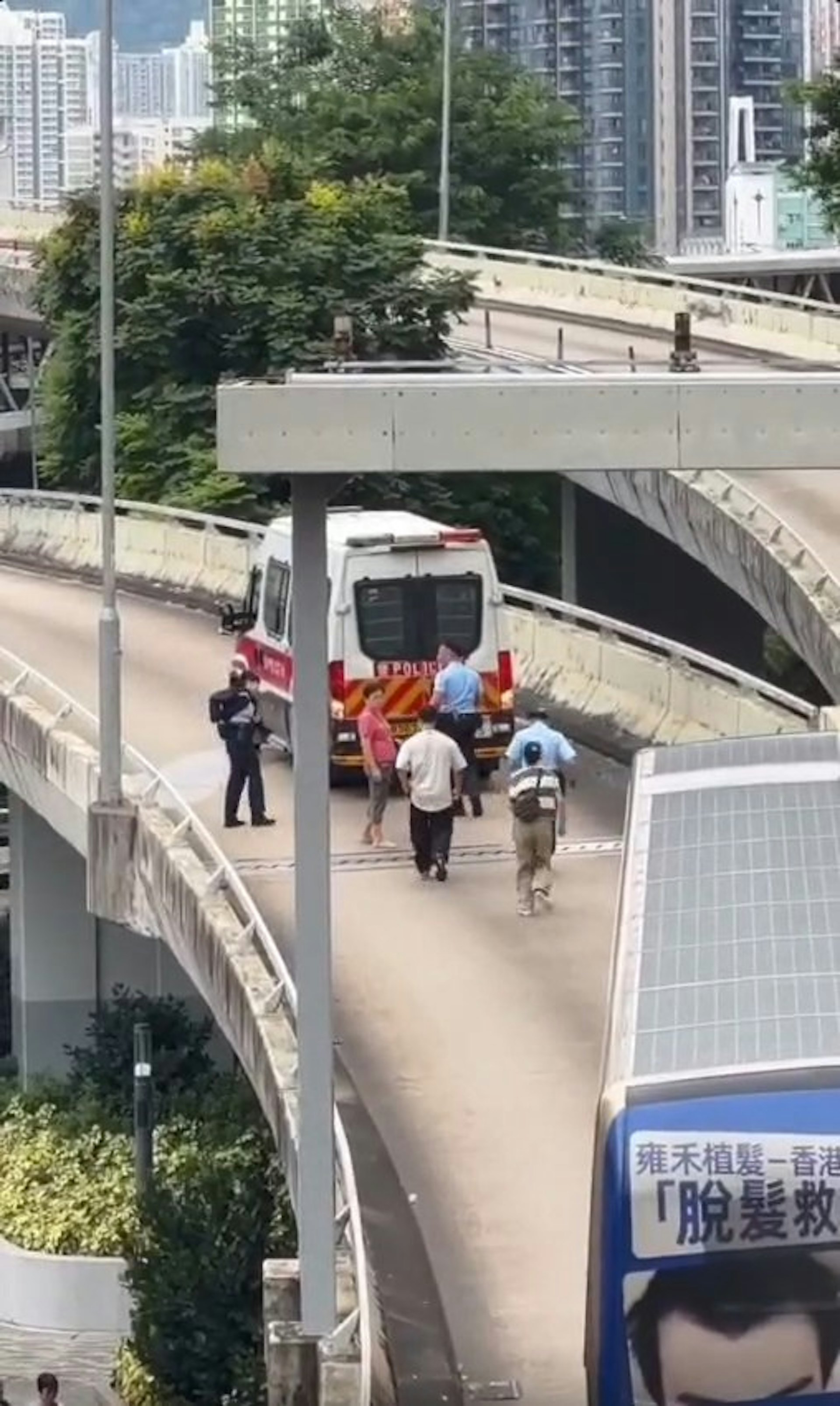 一輛警車於一條行車天橋「死火」,後方巴士被阻礙,接連有9人合力推車。(Facebook車cam L(香港群組)影片截圖)