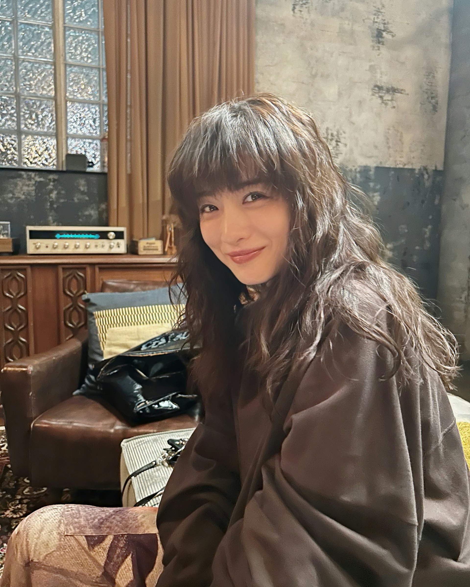 石原里美換上蓬鬆捲髮及率性私服服飾,飾演天才怪盜「如月彌生」。(X@politicalupin)