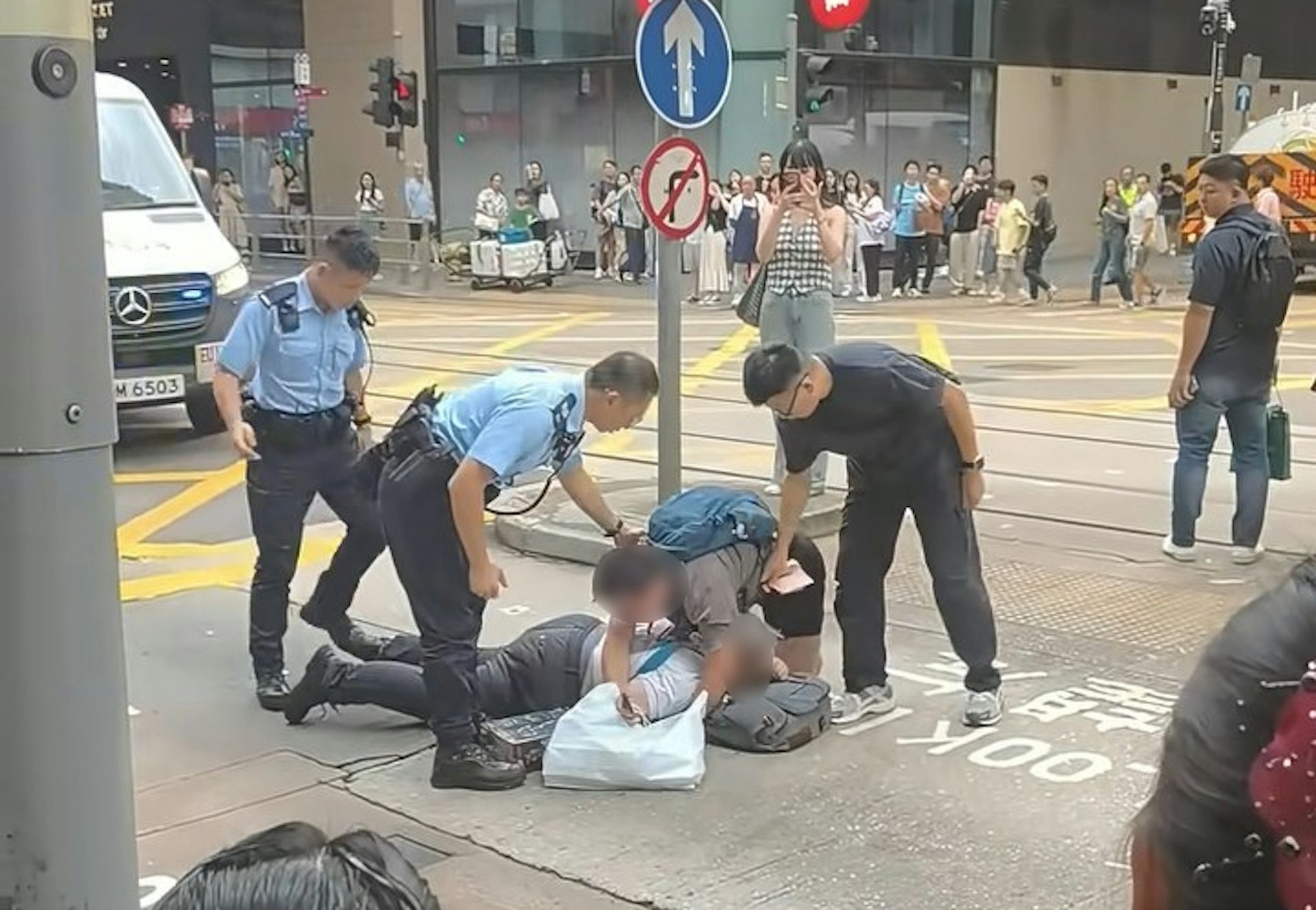 兩名男子疑在中環德輔道中與租庇利街交界,因身體碰撞爆發衝突,其中一名穿短褲、揹藍色背囊的男子,將另一名穿長褲的男子壓在地上。警員接報趕到現場,背囊男按指示放開長褲男。(小紅書/小红薯6AB38E3F)