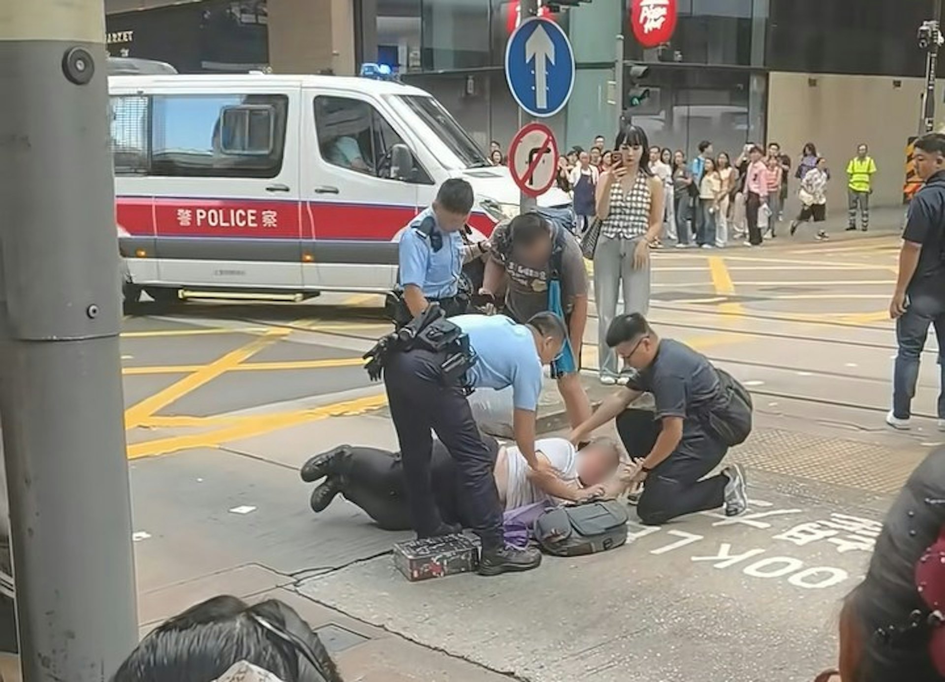 兩名男子疑在中環德輔道中與租庇利街交界,因身體碰撞爆發衝突,其中一名穿短褲、揹藍色背囊的男子,將另一名穿長褲的男子壓在地上。警員接報趕到現場,背囊男站起後,警員即查看仍伏在地上的長褲男情況。(小紅書/小红薯6AB38E3F)
