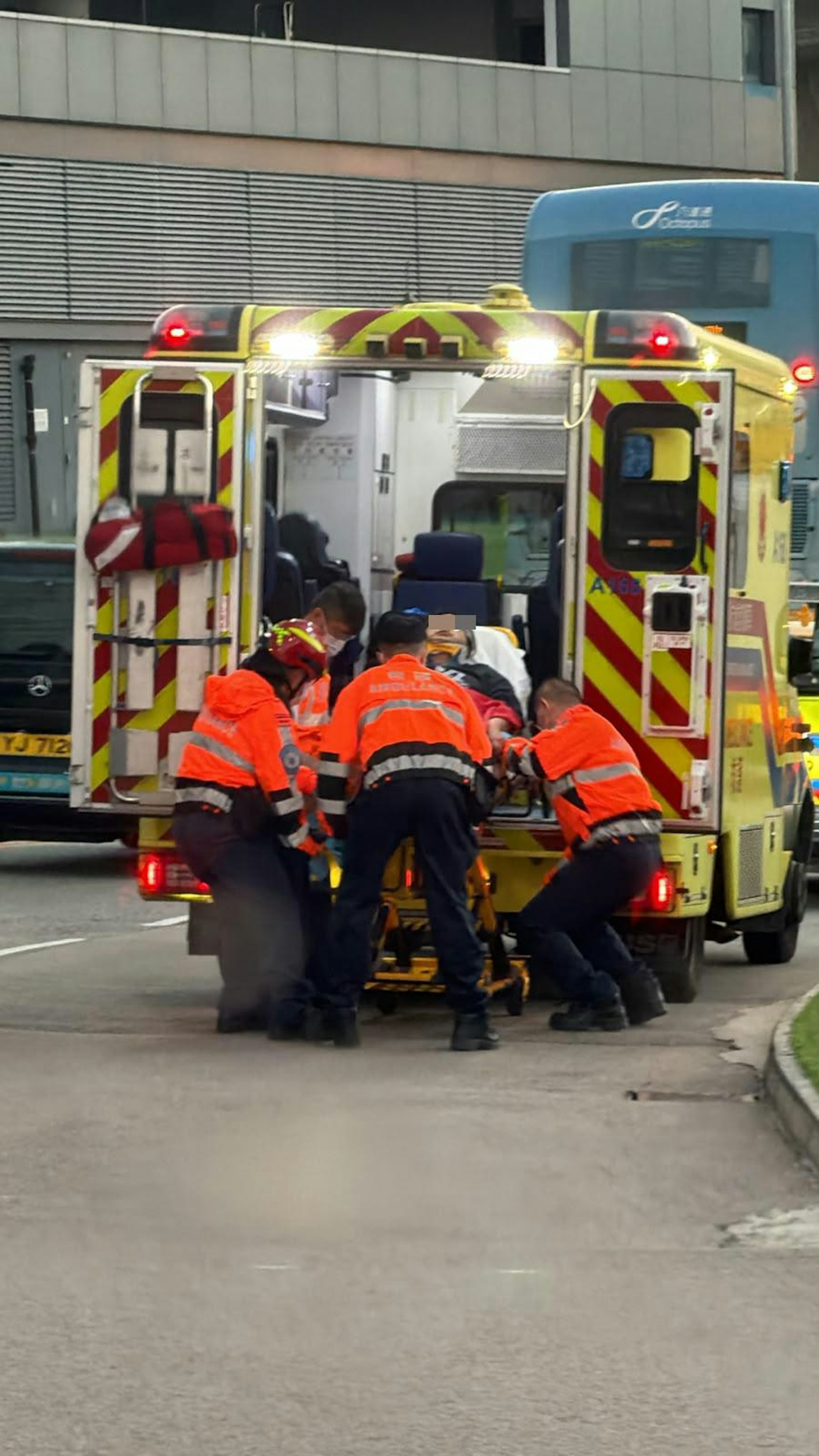 司機坐在擔架床,被送上救護車。