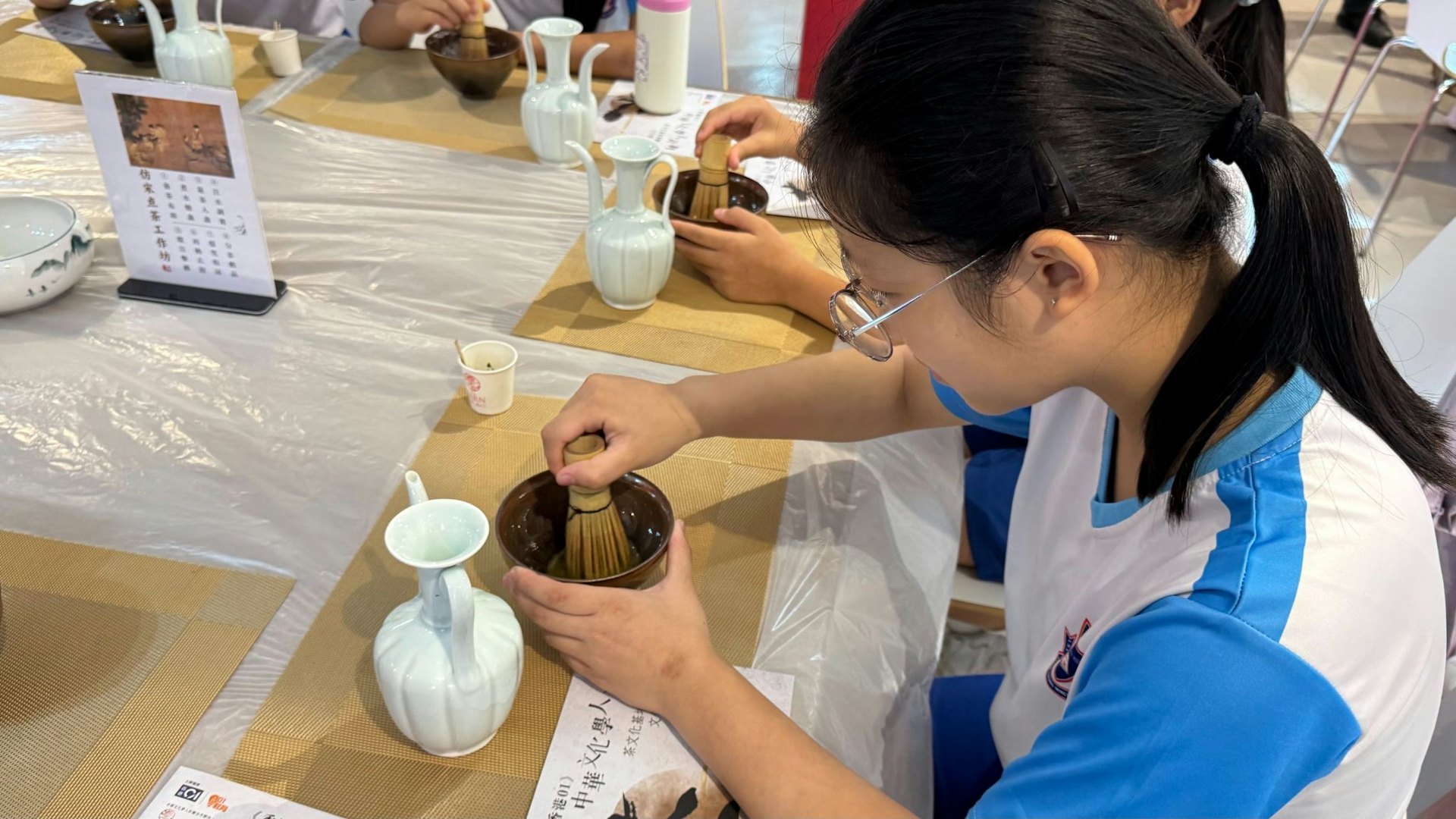 學生學習用茶筅嘗試擊打出綿密潔白的茶沫,在動態操作中領略古人以茶會友的情趣與精細手藝。