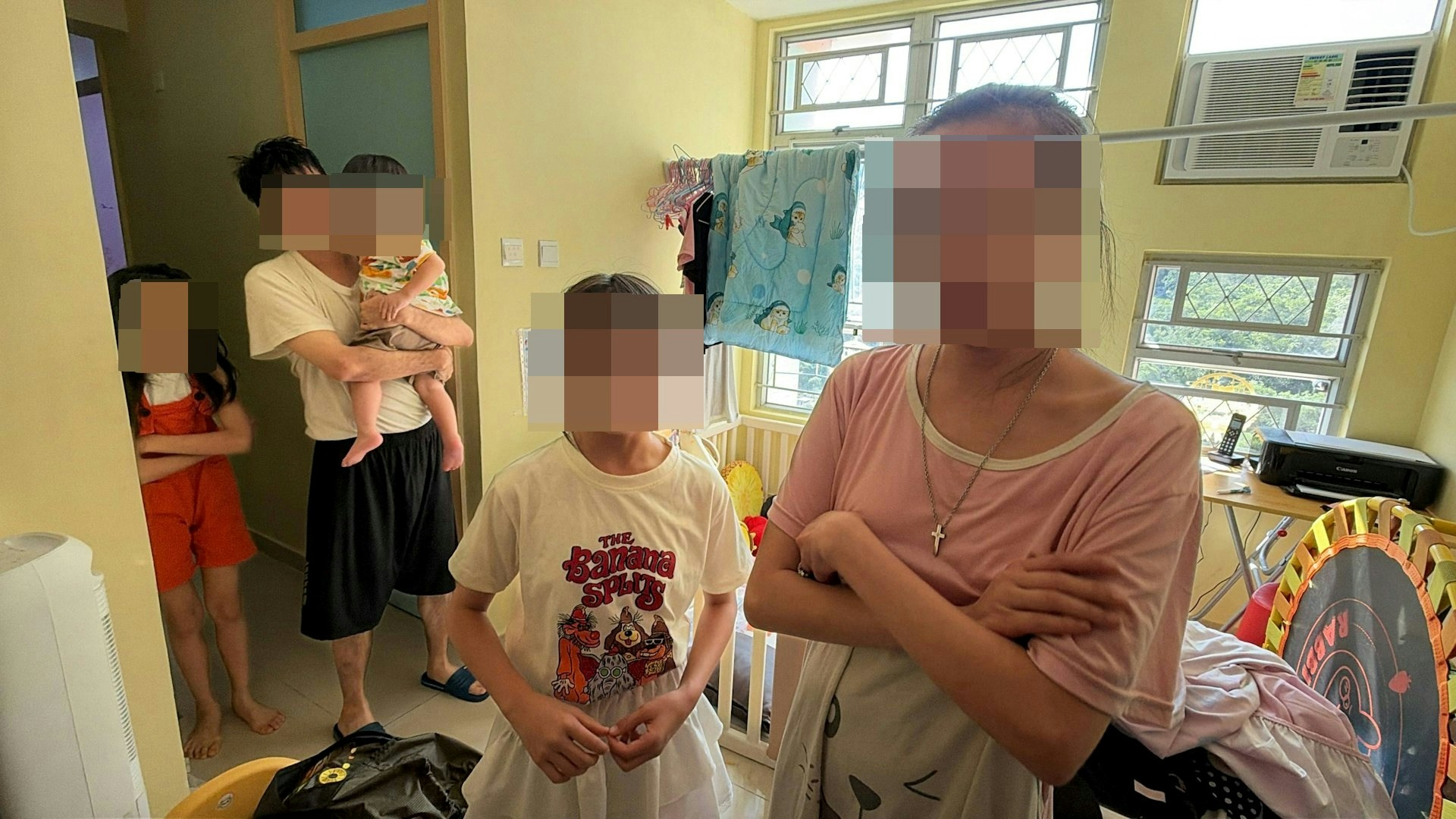 涉事女童(白衫)與父母及弟妹在住所內見記者。