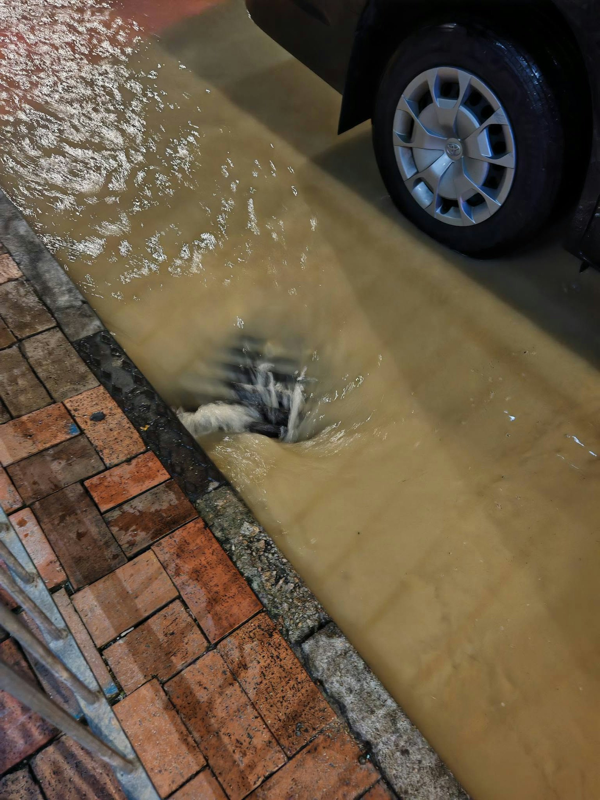 黃泥水湧入路旁坑渠。(Facebook群組「香港鐵騎館(吹水區)」圖片)