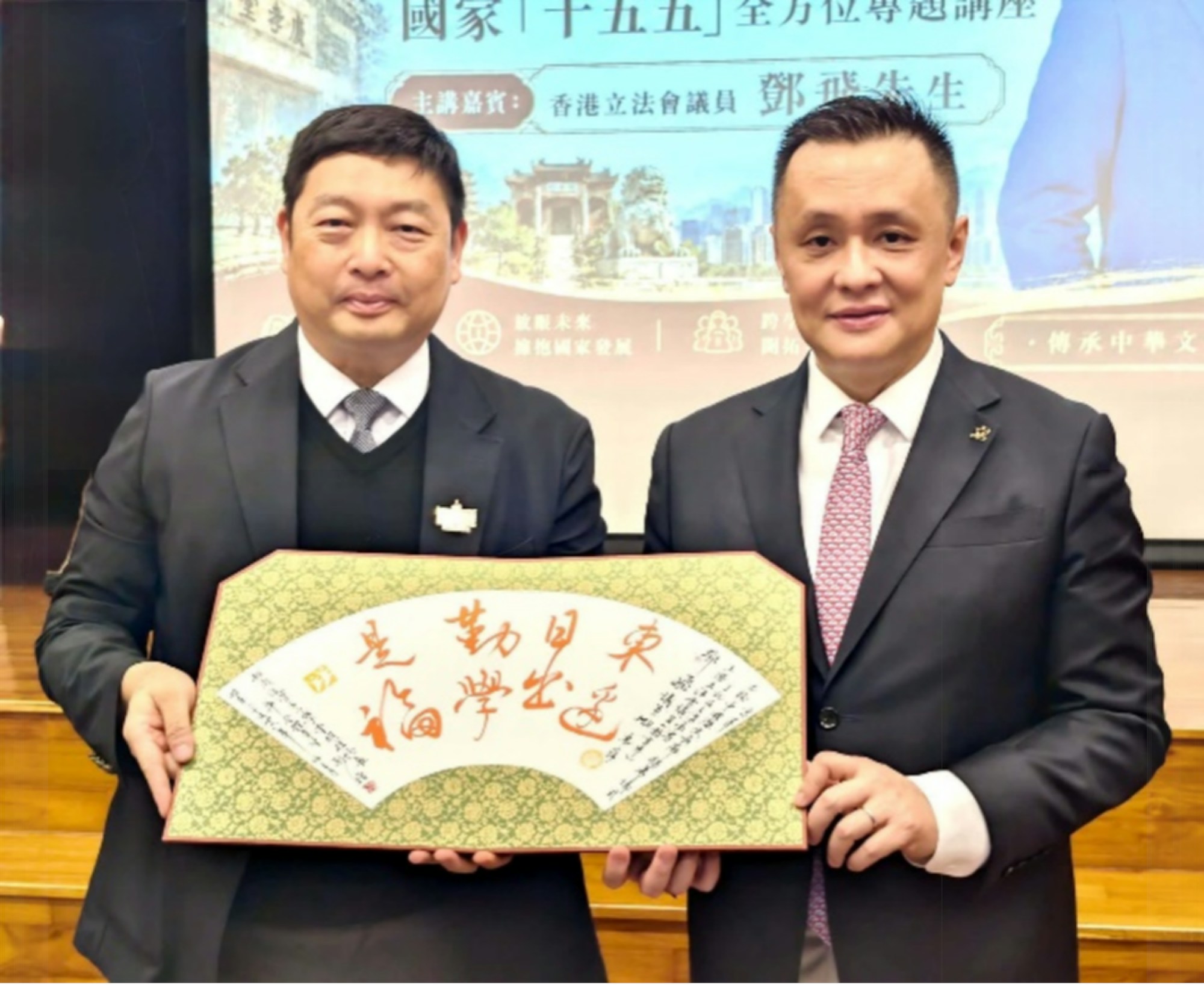 般咸道官立小學致送由香港聯合國教科文組織協會(書法)項目顧問潘炳鴻老師題寫的扇面紀念品予立法會議員鄧飛,寄託對教育的熱情與希望。