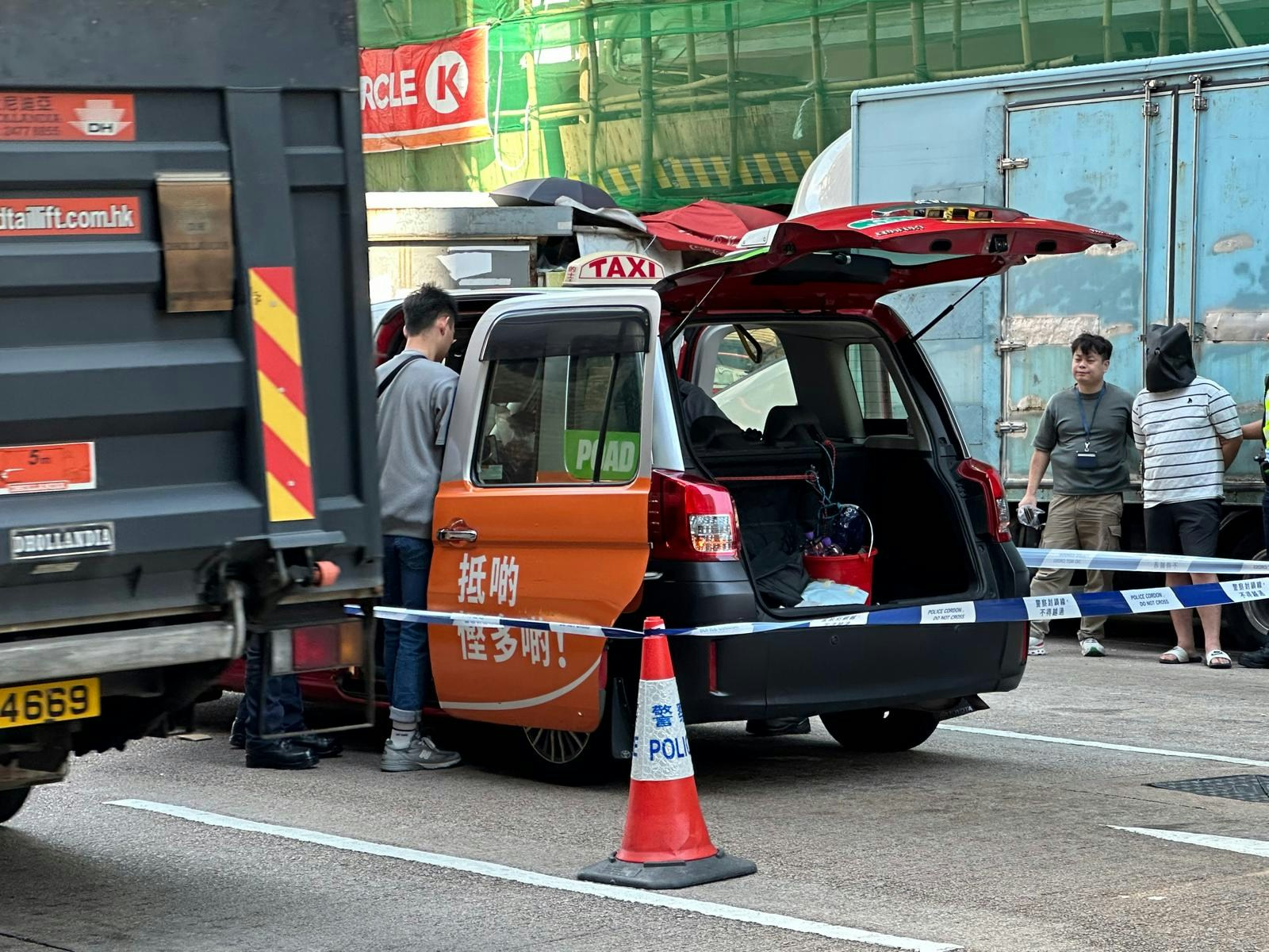 警方在場調查,其中一名男子被戴上手扣,黑布蒙頭。