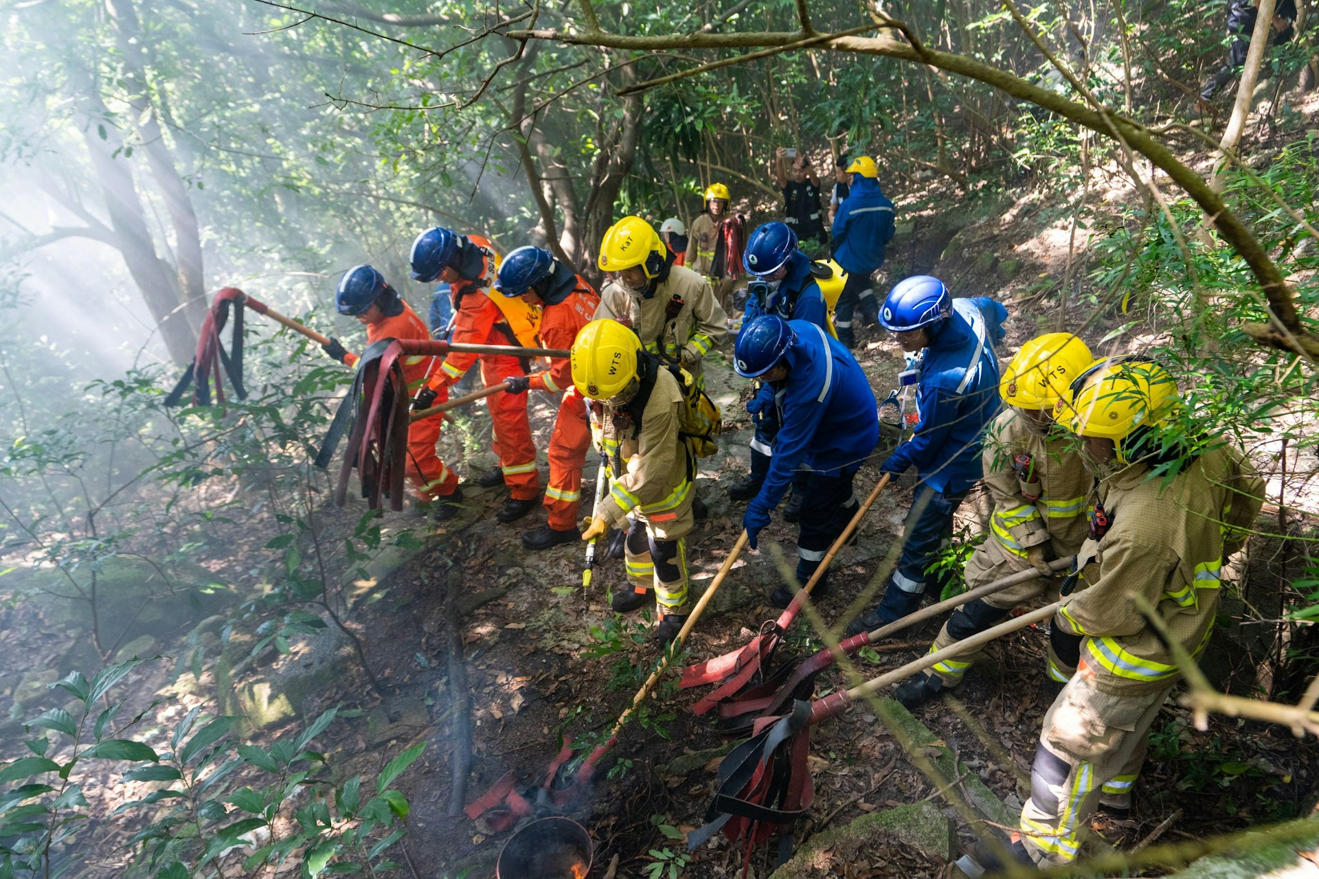 消防處、民眾安全服務隊和漁農自然護理署人員以山草拍模擬撲滅山火。