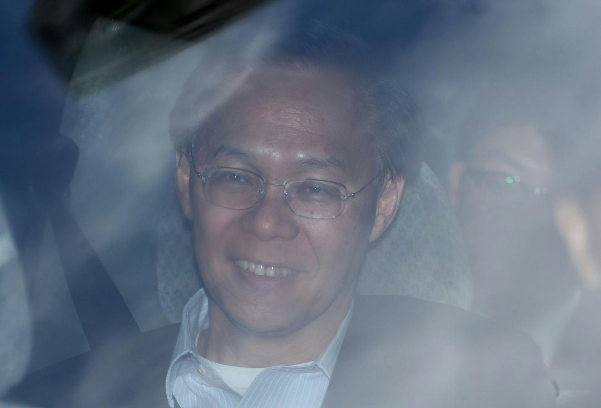 2012年7月12日,发展局局长麦齐光被廉政公署拘捕,他同日辞职。图为7月13日他离开廉署时,被大批记者包围。(SCMP / Getty Images)