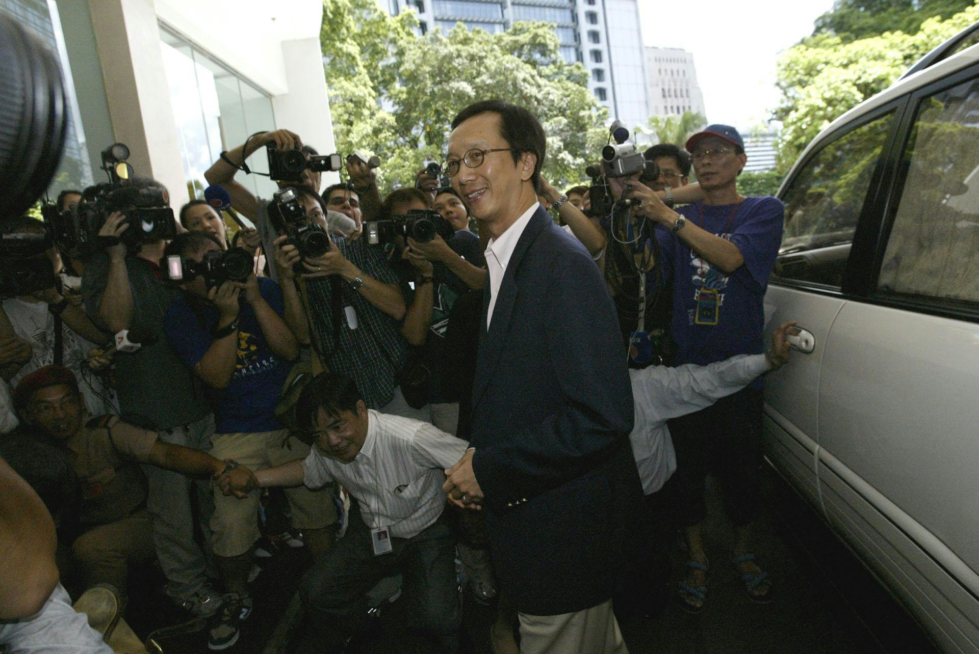 2003年7月16日,政府公布财政司司长梁锦松辞职。图为7月17日梁锦松进入政府总部时,被大批记者包围。(SCMP / Getty Images)