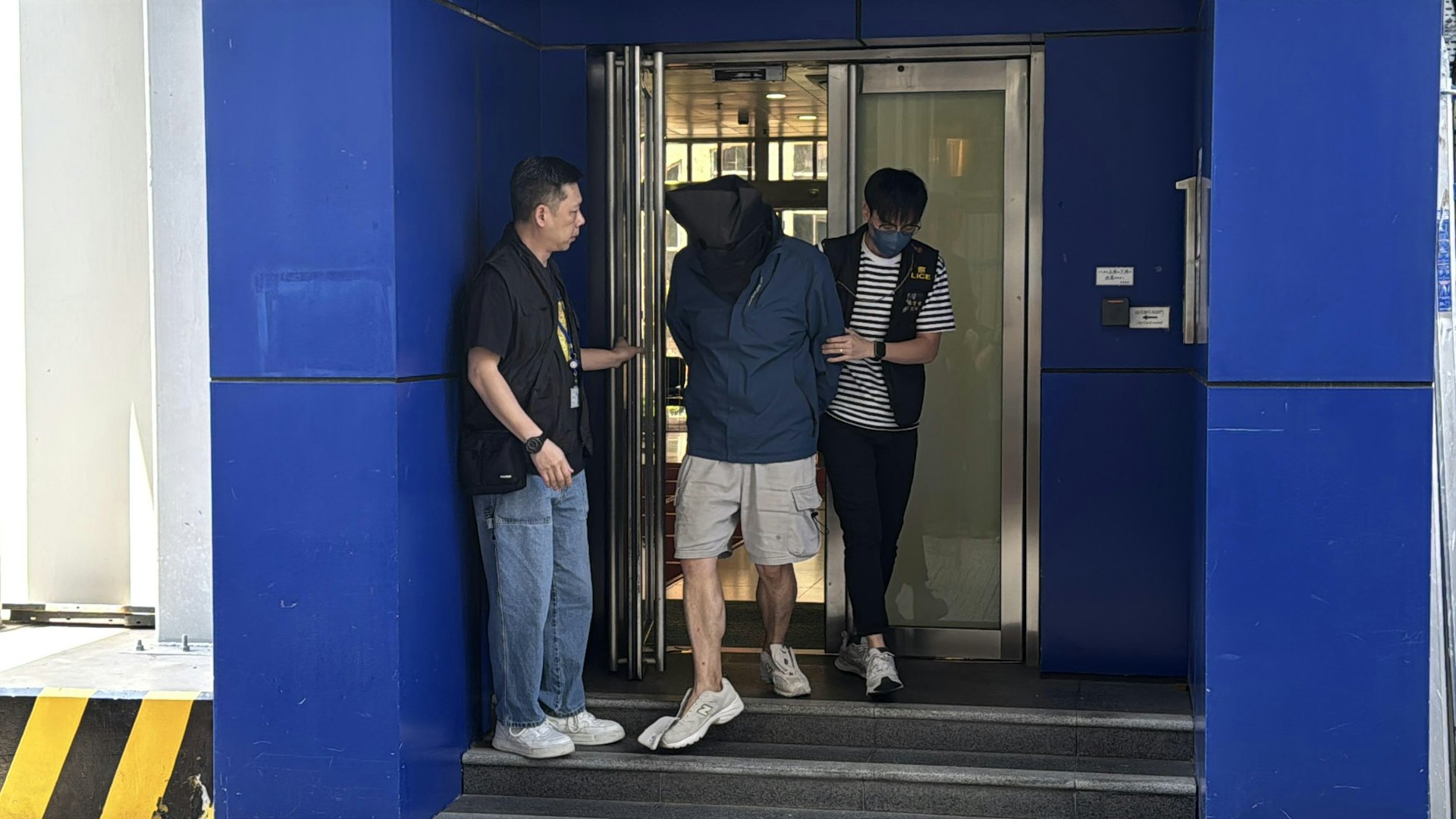 警方拘捕16人,當中4人為骨幹,而有3人為親兄弟。圖為其中一名疑犯被押走。