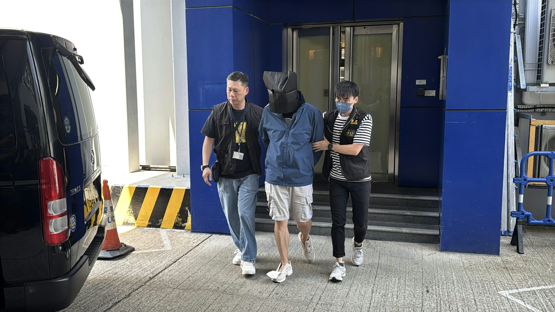 警方拘捕16人,當中4人為骨幹,而有3人為親兄弟。圖為其中一名疑犯被押走。