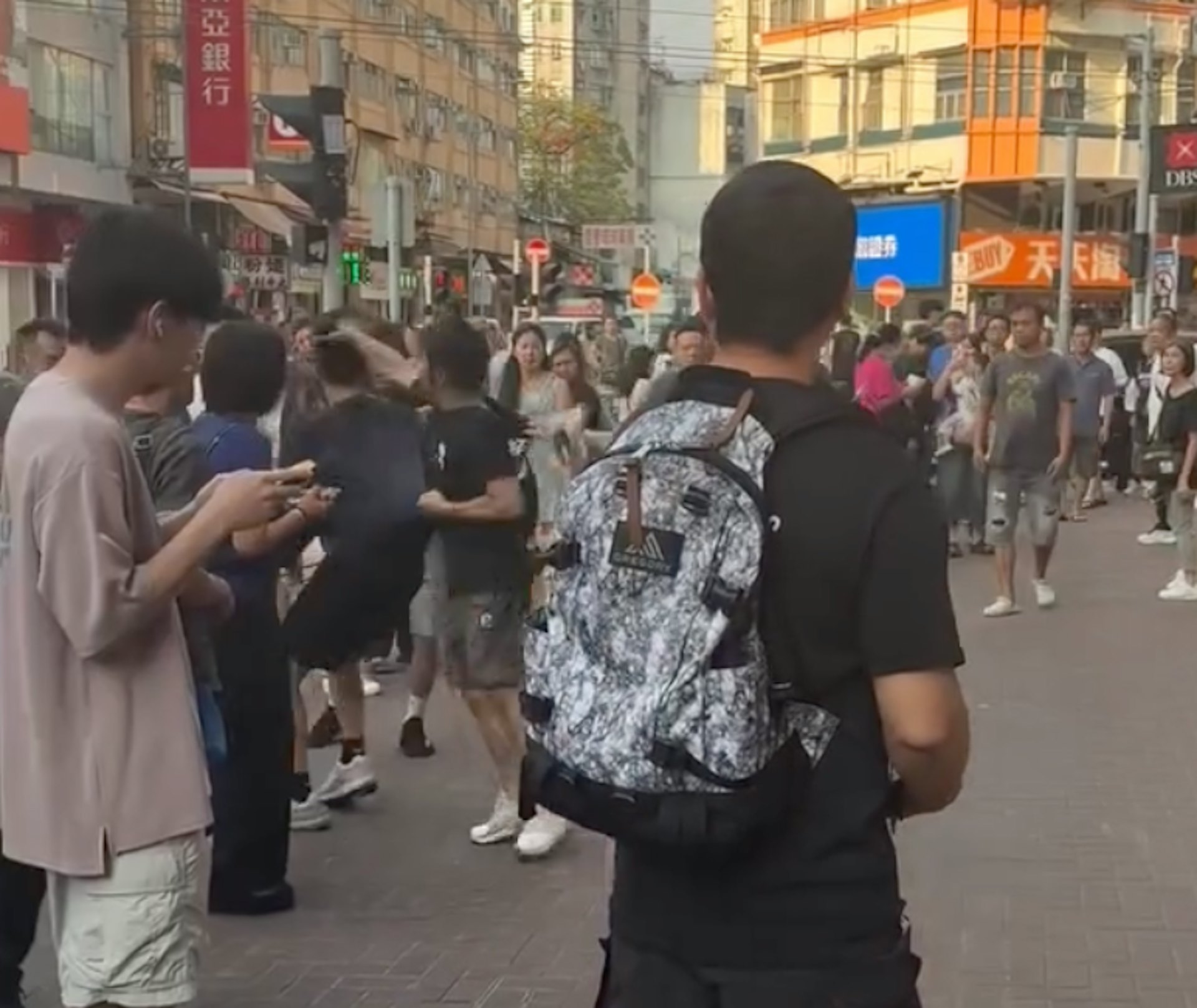 灰褲男奮起,左手扯住眼鏡男上衣,右手打頭。