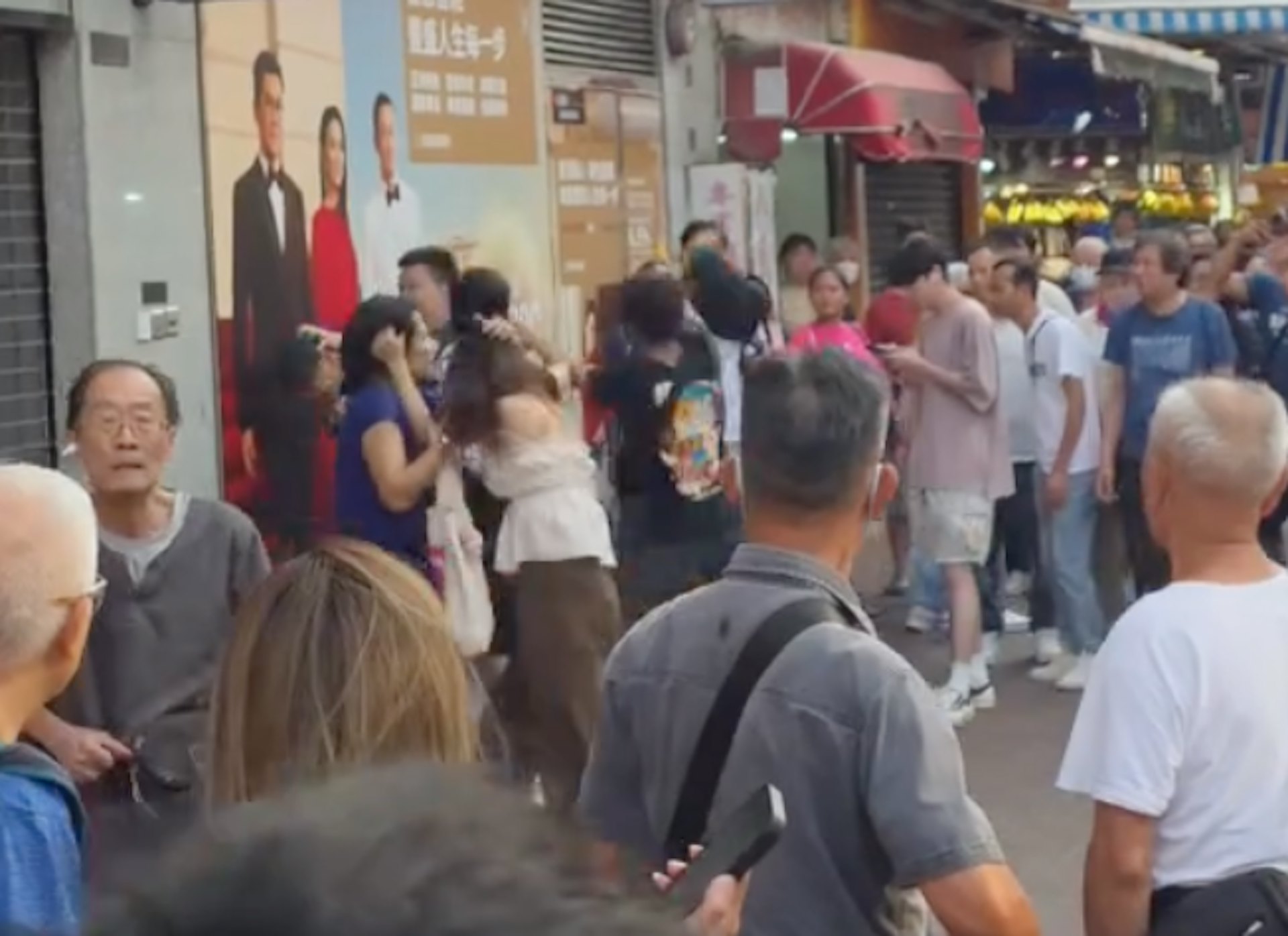 眼鏡男與另外兩名男子扭打成一團;兩名女子則互相扯頭髮。