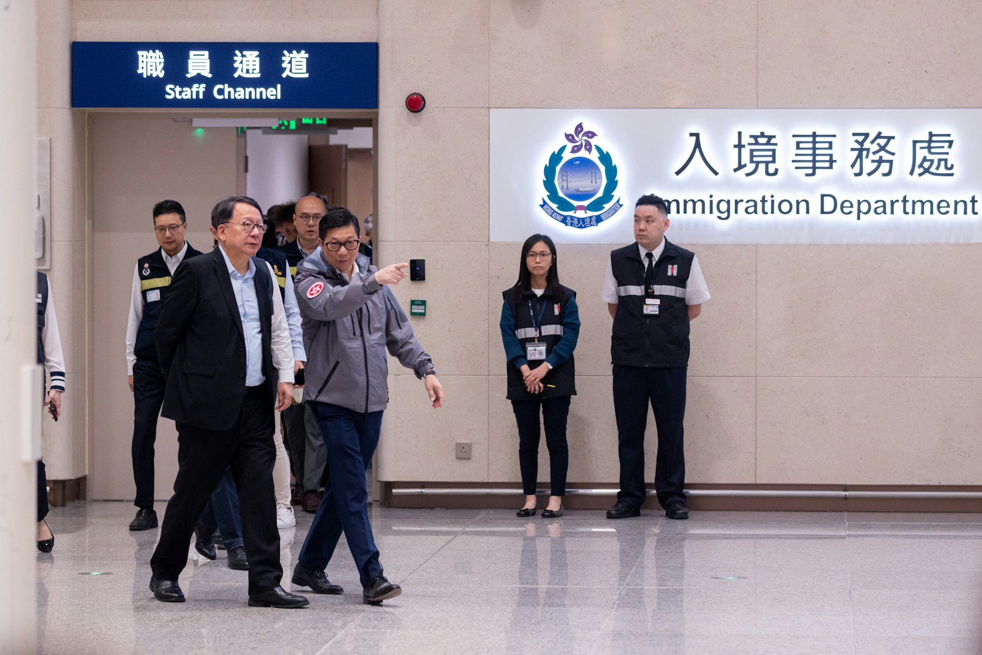 新皇崗口岸10月12日開通,政務司司陳國基(左一)及保安局局長鄧炳強(左二)等在皇崗口岸正式啟用後與過關人士傾談。