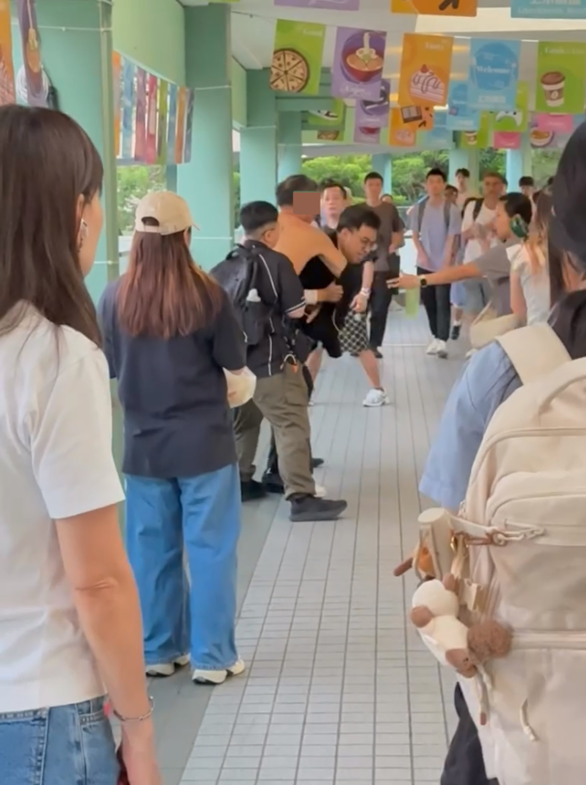網上片段顯示,當時有兩名男子合力捉住一個上身赤裸的男子,並將他壓向天橋的欄杆位置。(yu__yui_片段截圖)