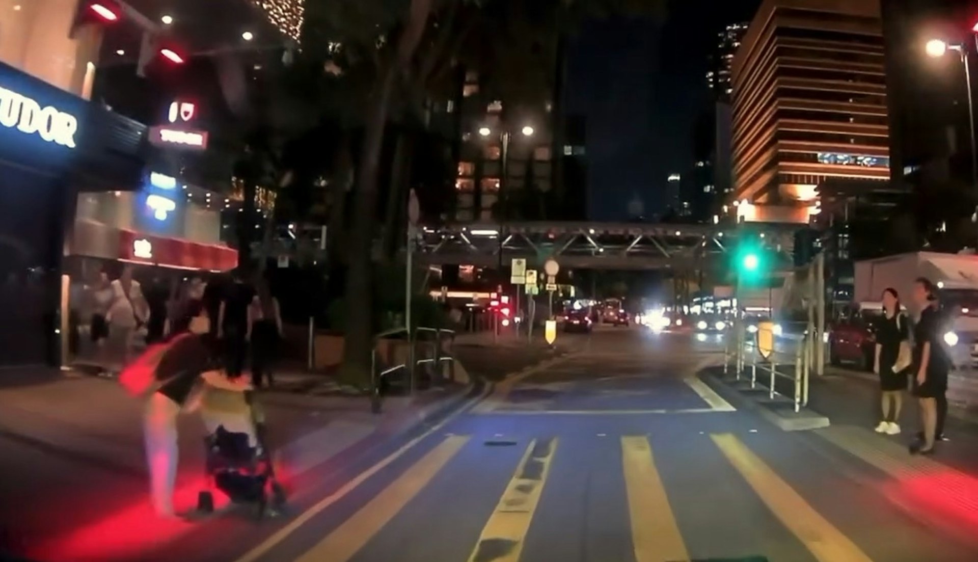 【連環圖】尖東一名婦人,懷疑意圖推BB車衝紅公仔,此時車CAM片主的車輛駛至,雙方及時煞停,未有造成意外。(網上片段截圖)