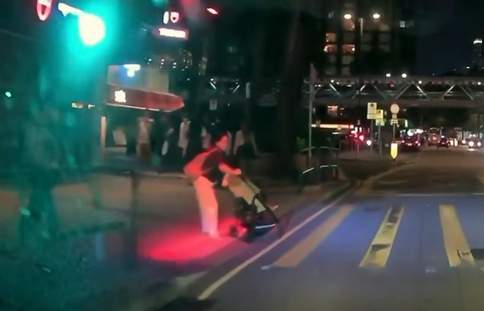 【連環圖】尖東一名婦人,懷疑意圖推BB車衝紅公仔,此時車CAM片主的車輛駛至,雙方及時煞停,未有造成意外。(網上片段截圖)