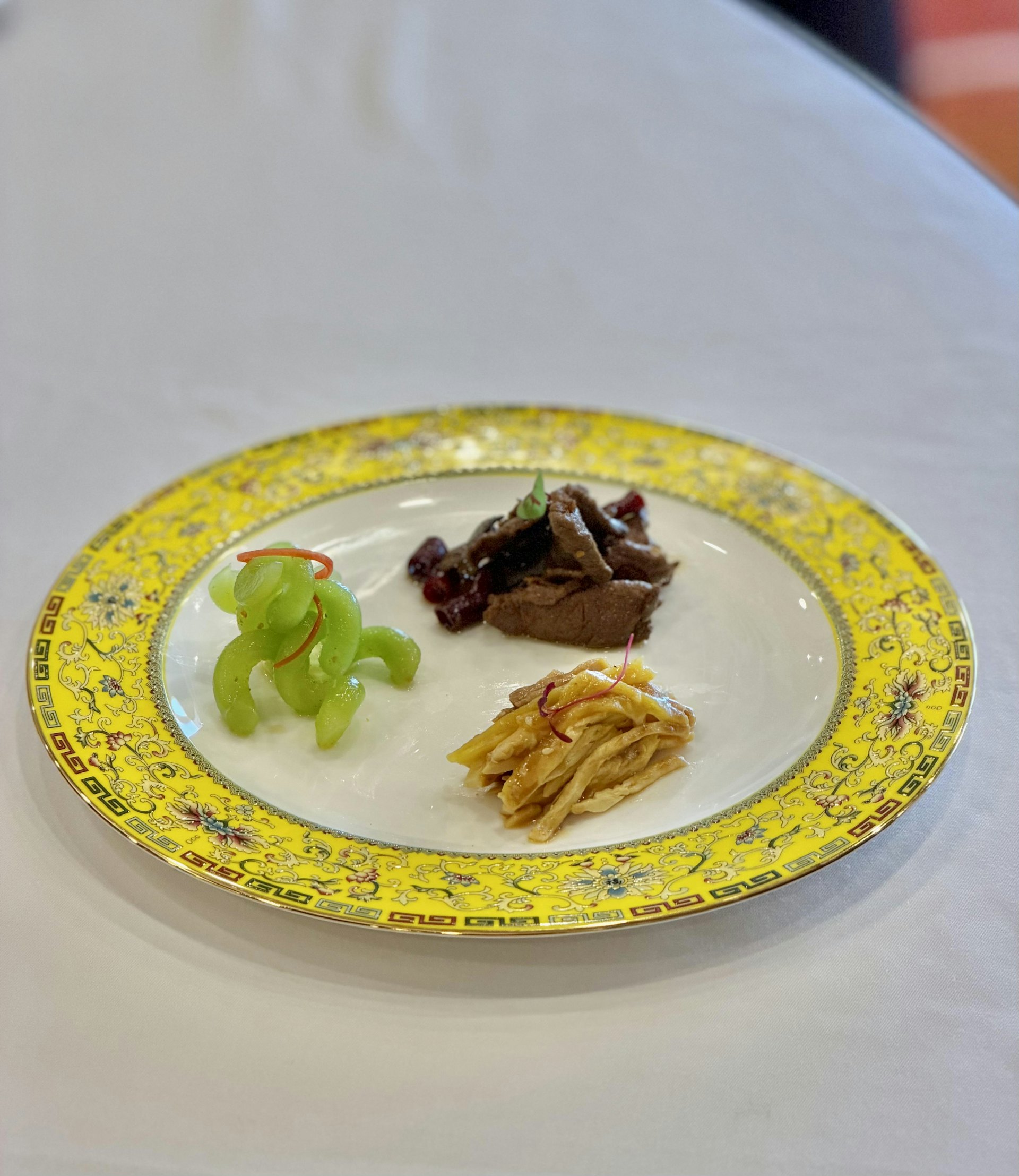 结业晚宴呈献多道精致川菜,包括「三色前菜―怪味鸡丝、酸辣莴笋丝、陈皮牛肉」、「鸡豆花」及「糯米樟茶鸭」等经典菜式,充分展现学生于成都培训期间所学所悟,融会贯通川菜技艺,完美演绎川菜「一菜一格、百菜百味」的独特魅力。- 「三色前菜―怪味鸡丝、酸辣莴笋丝、陈皮牛肉」。