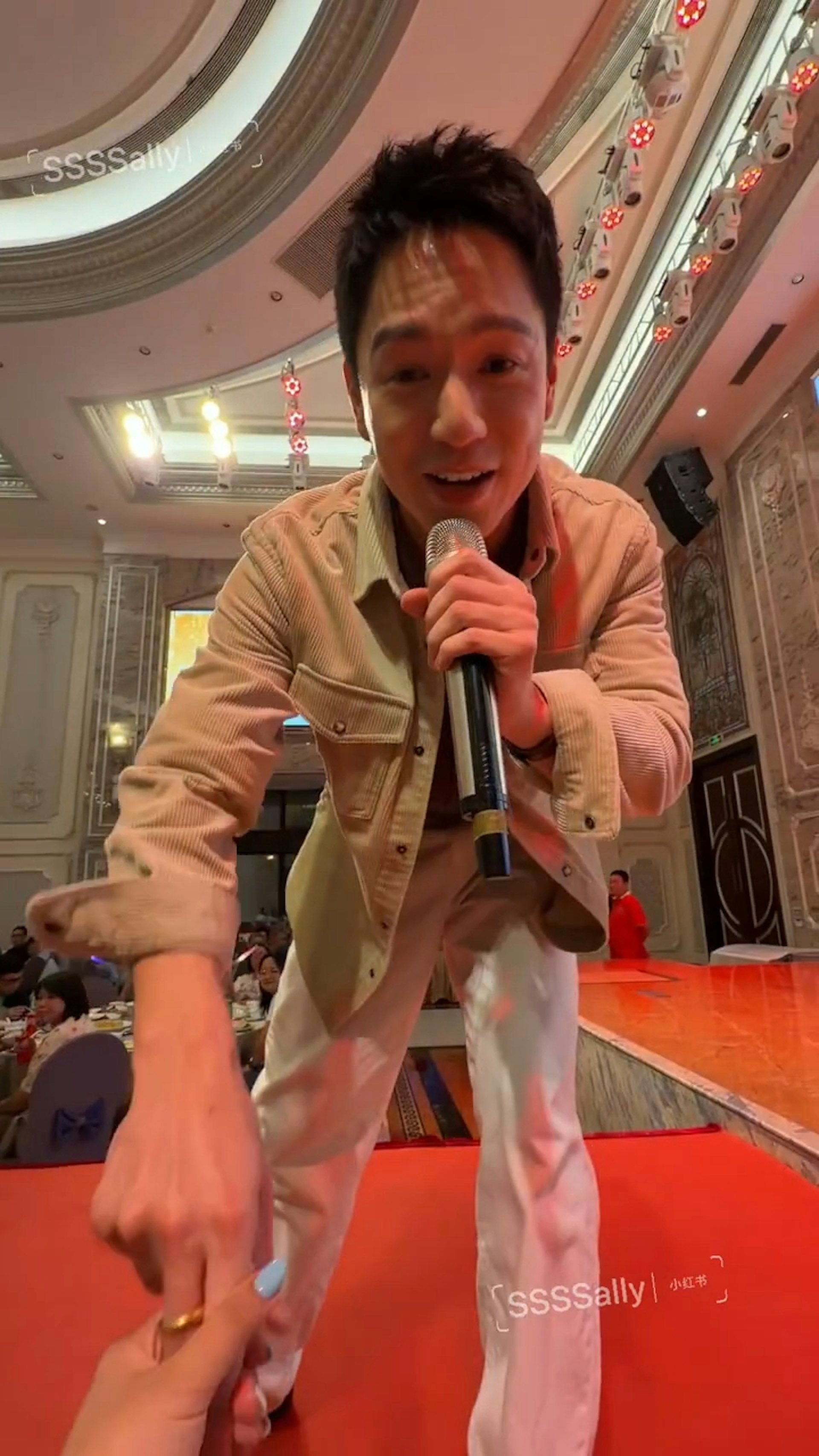 吳偉豪邊唱邊沿著台邊走,然後去到這位網民面前指一指了手機。