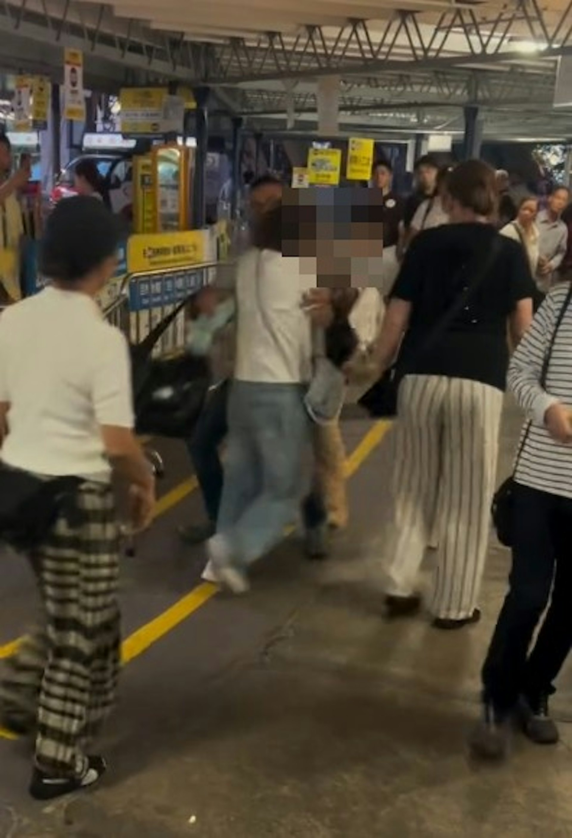 【連環圖】恤衫女將婦人撳在地上打頭。一名外籍男走近勸阻。(網片截圖)