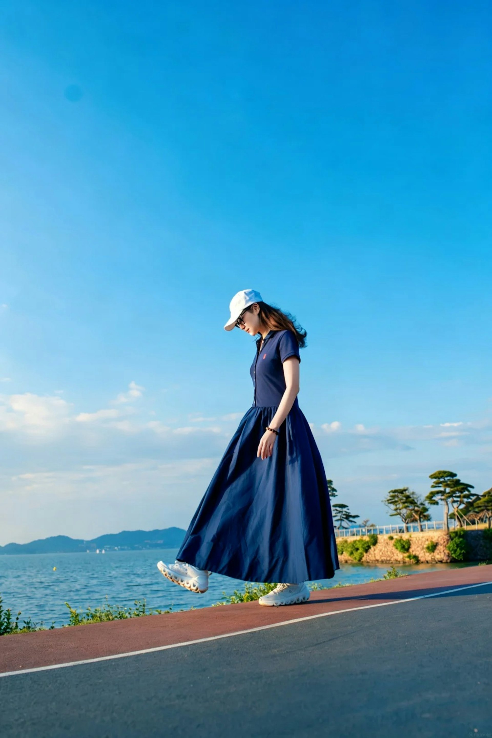 万绮雯站在黄昏时分的湖畔走道,低头漫步享受微风与落日交织的宁静时刻。(小红书照片)